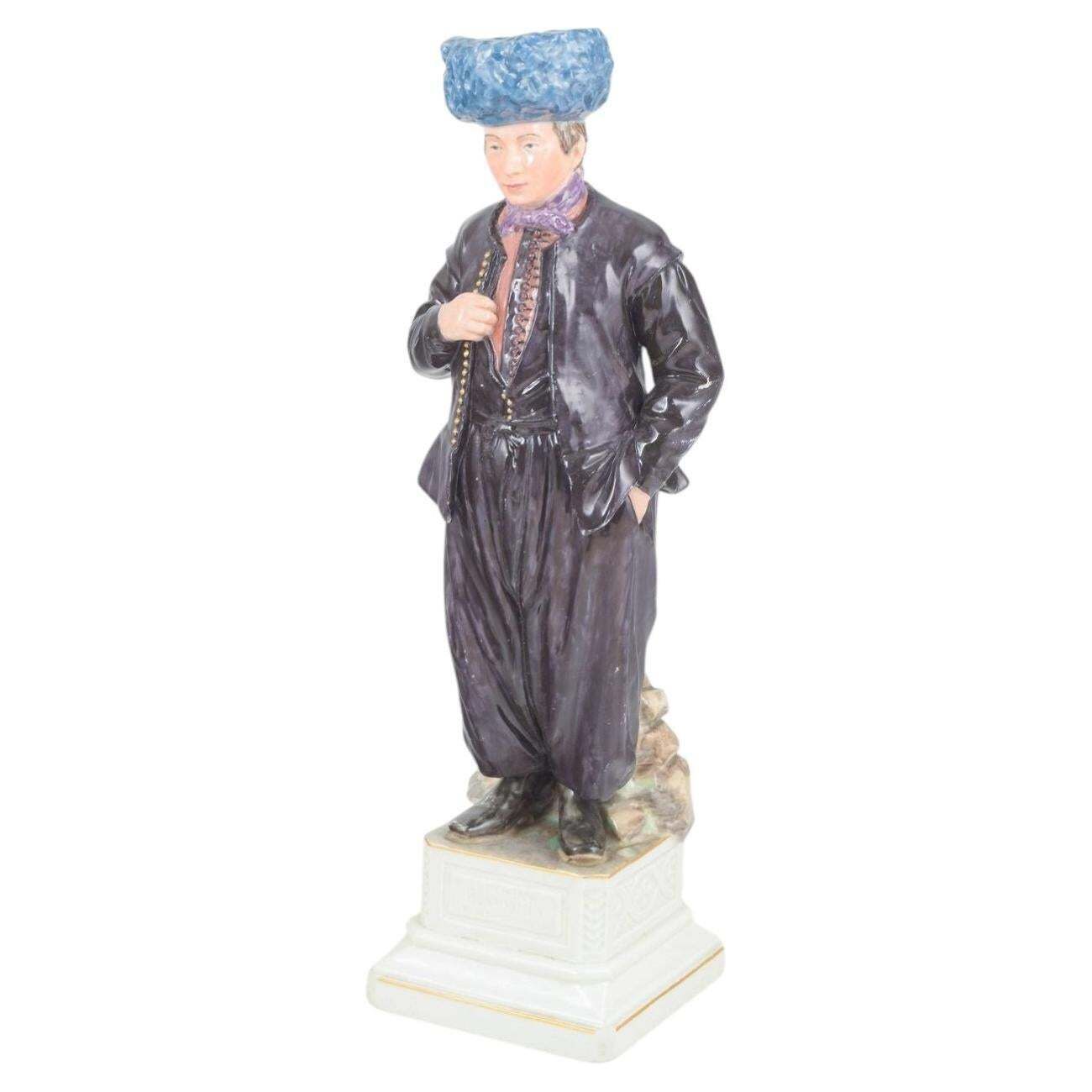 Royal Copenhagen. Porseleinen figuur van man in traditioneel streekdracht.