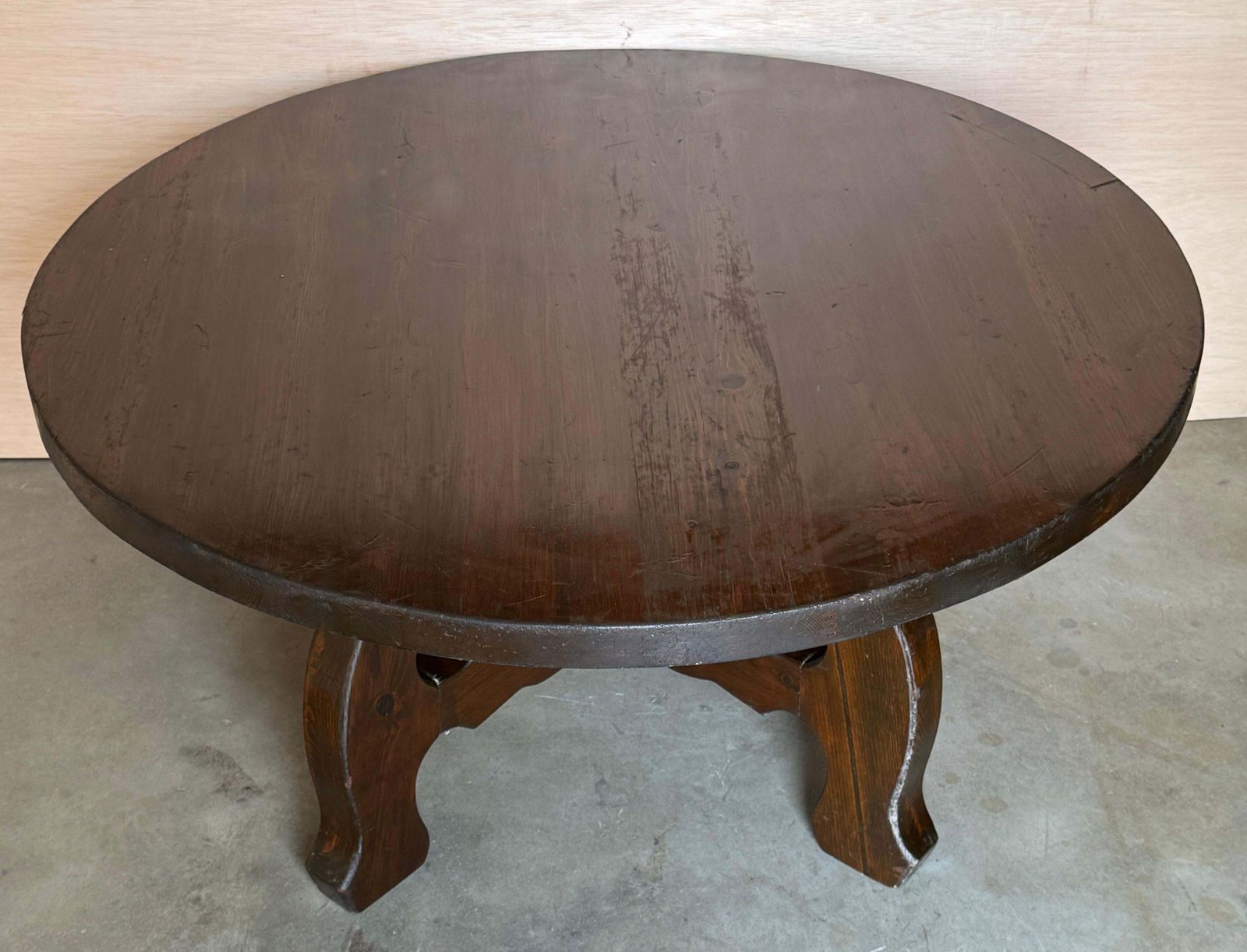 photo furniture Table basse espagnole rustique en noyer massif, plateau rond et piètement en tréteau à lyres sculptées, années 1940