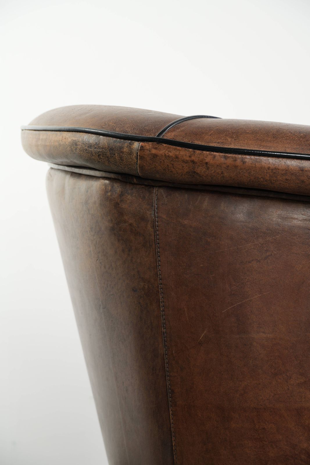 photo vinterior Strakke art deco schapenvacht club fauteuil met zwarte biesafwerking