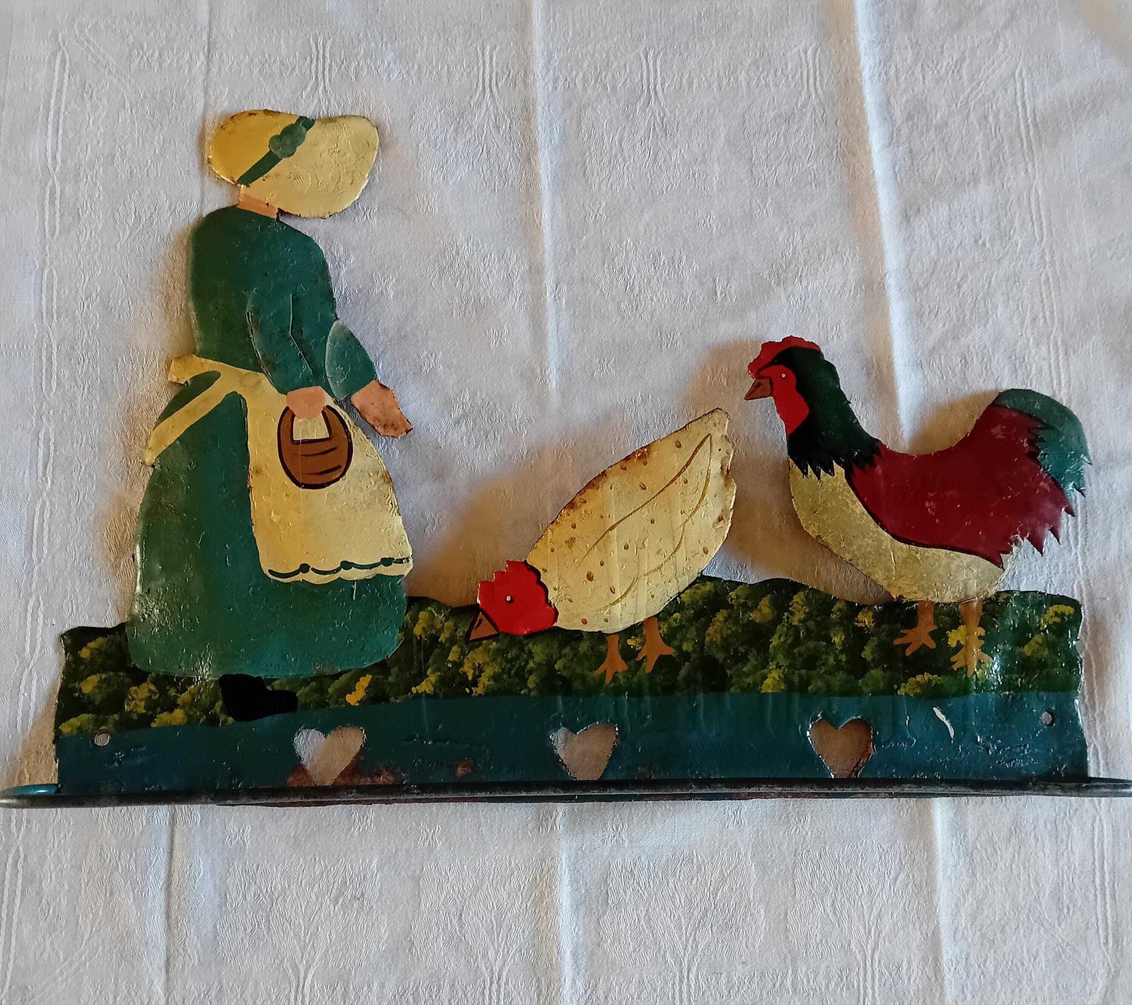 Porte-torchons en art populaire : cintre à torchons avec une femme nourrissant ses poules