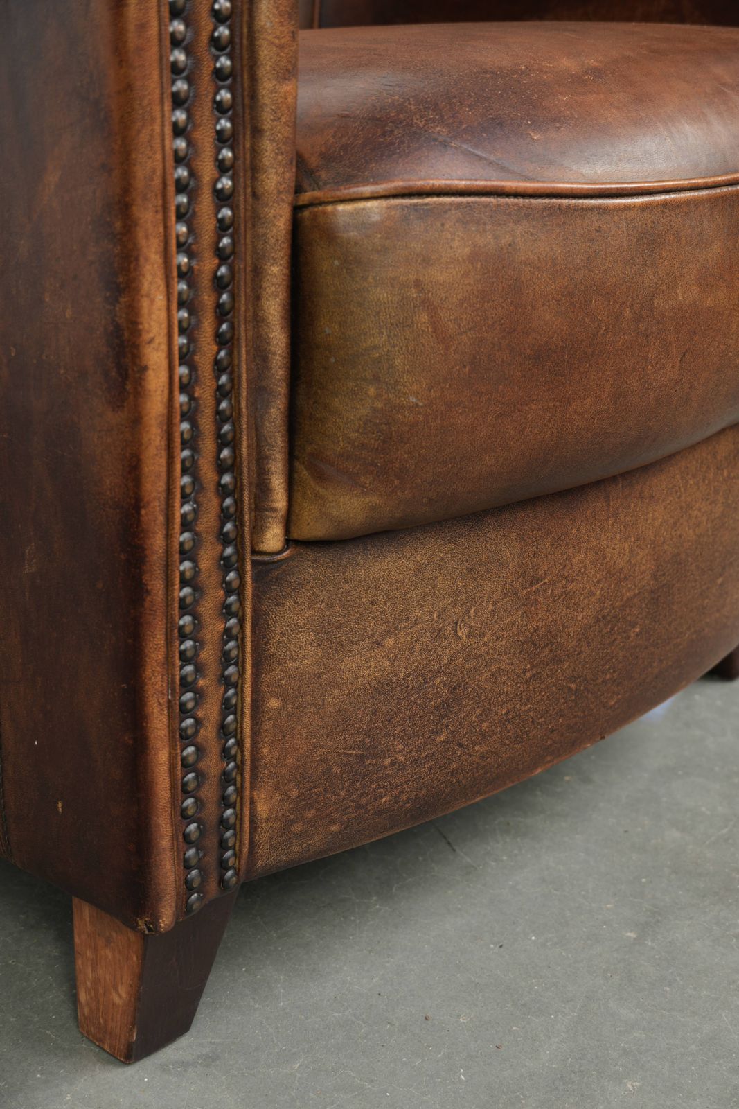 887.0 Stevige en karaktervolle clubfauteuil in schapenleer met een mooie patina, afgewerkt met decoratieve nagels. photo