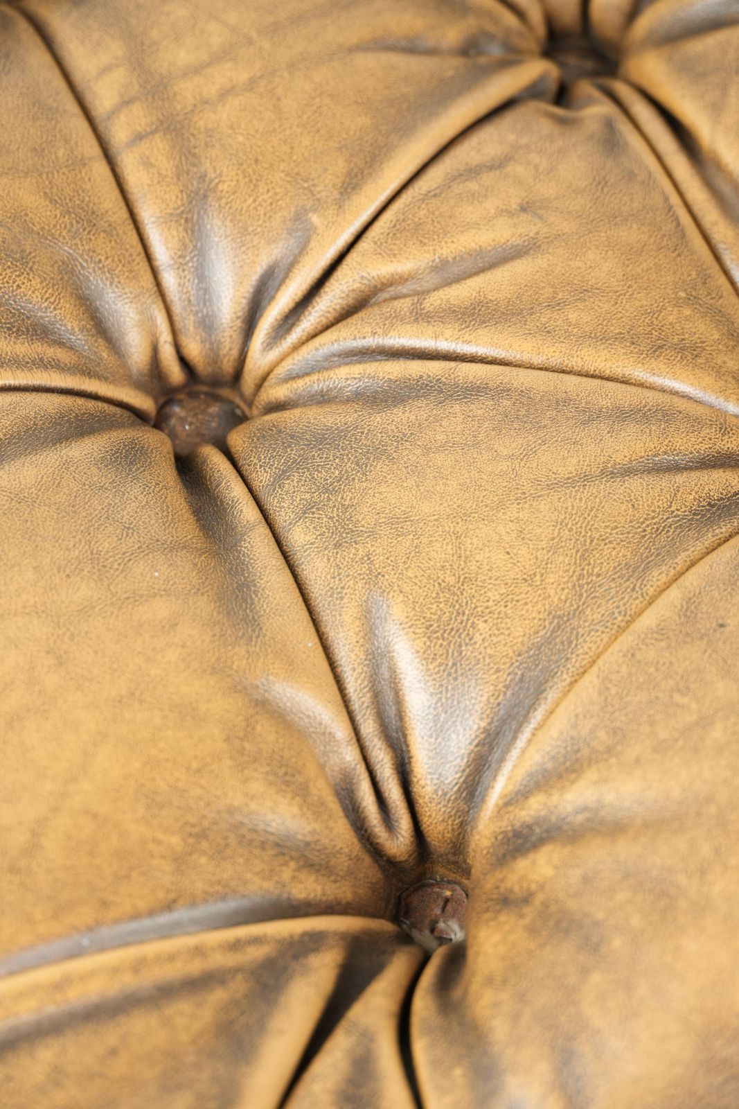514.0 Unieke en elegante Engelse Chesterfield ottoman in koeienhuidleer op wieltjes, afgewerkt met decoratieve nagels. photo