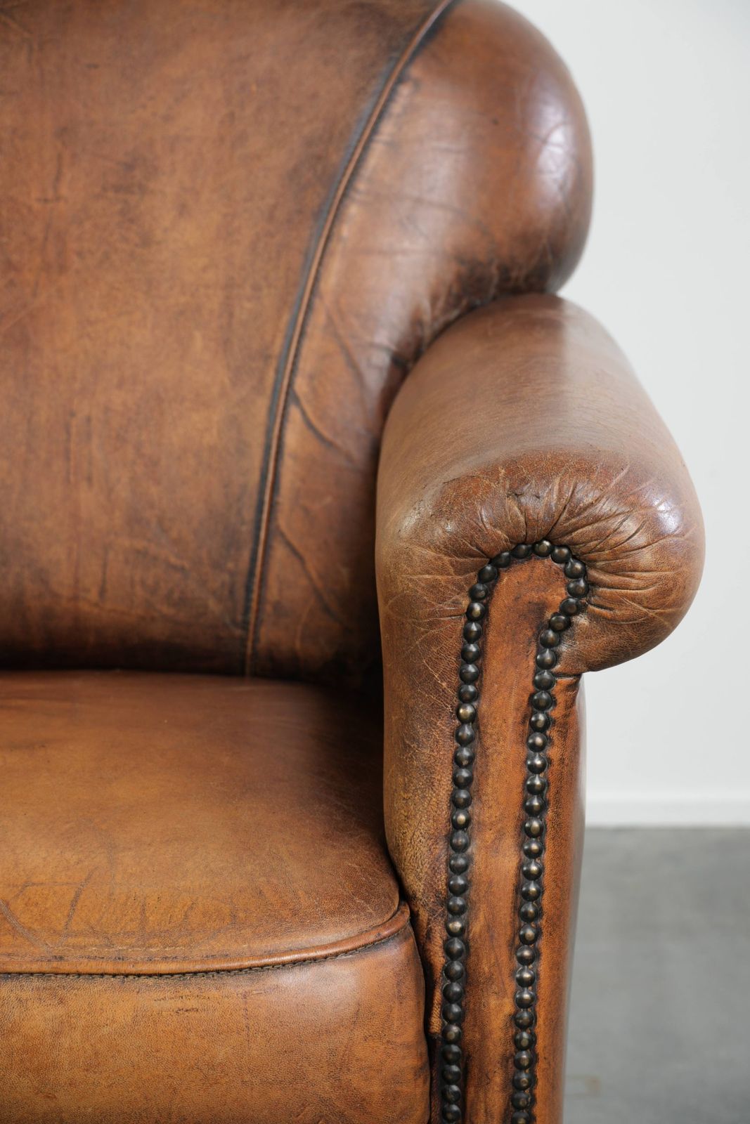 photo furniture Comfortabele fauteuil met schapenvacht, decoratieve spijkers en mooie patina