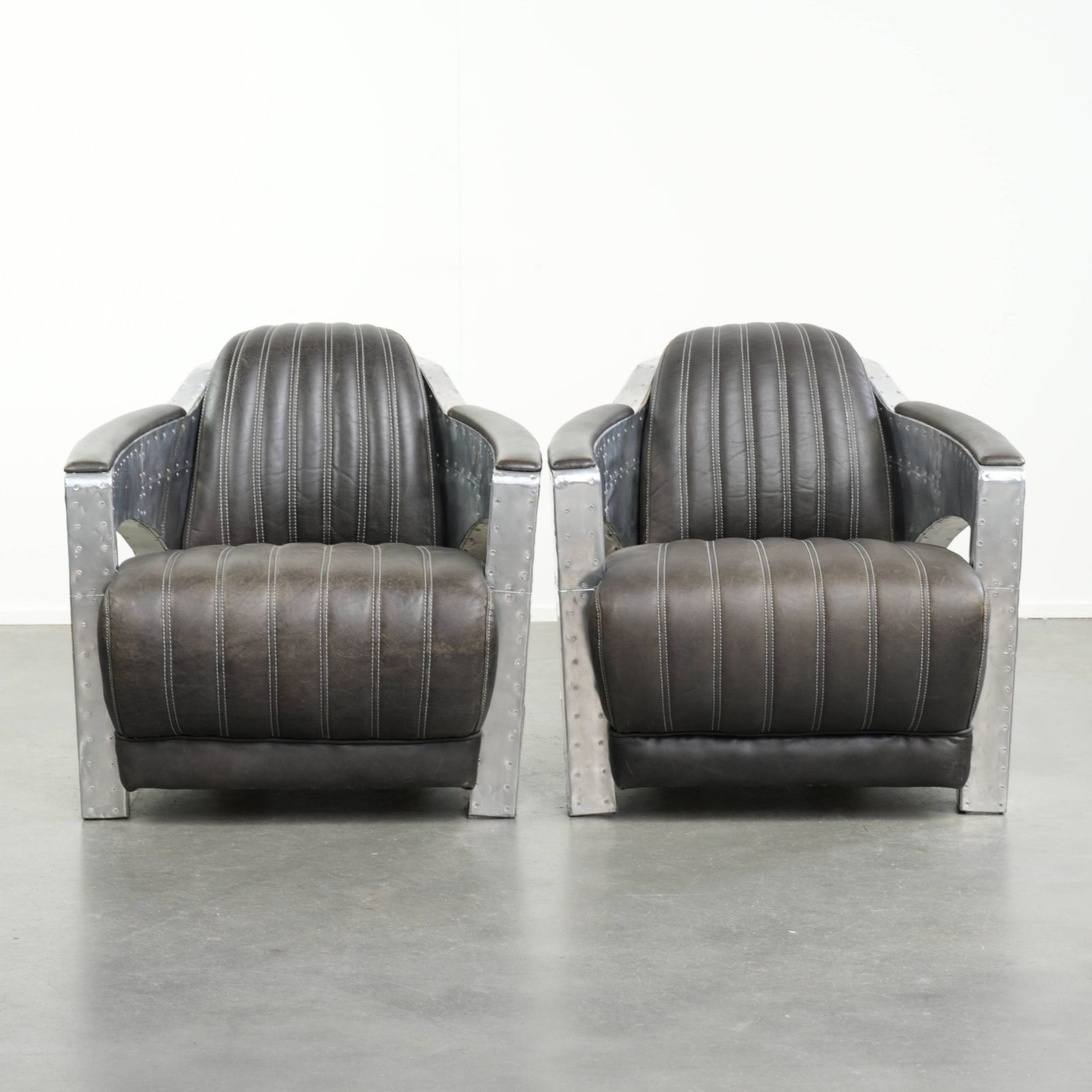 Set van 2 robuuste industriële zwarte koeienhuid Aviator design fauteuils met aluminium en klinknagels