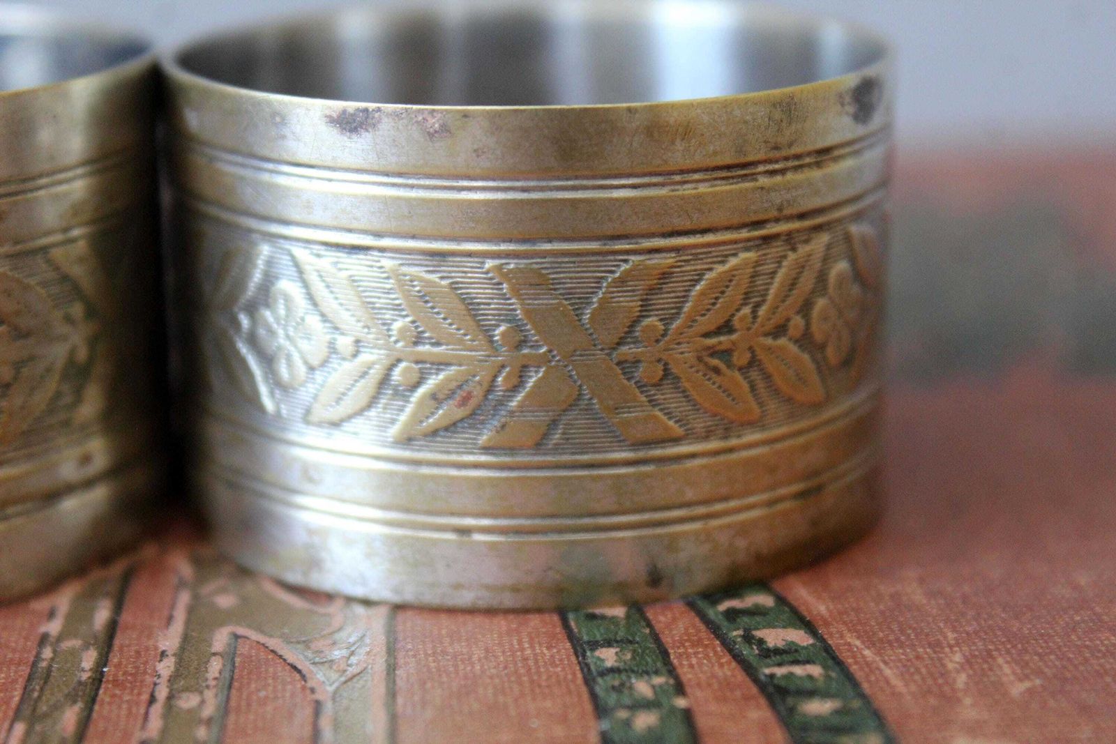 photo for sale Lot de trois ronds de serviette d'époque français en métal argenté, décoration de table à manger, motif Regency Empire à feuilles de laurier et fleurs