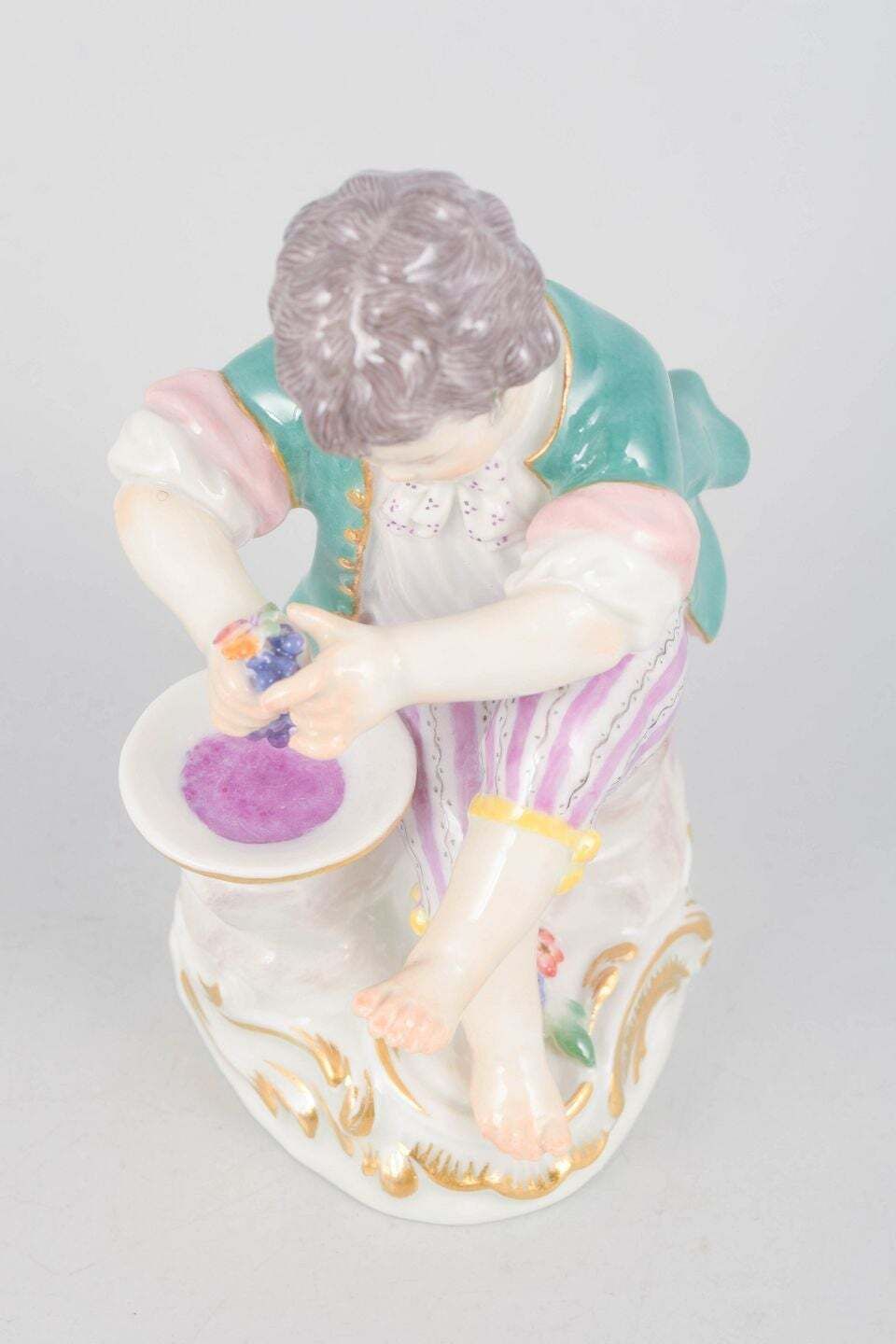 Meissen, Duitsland. Porseleinen beeldje van jongen die druiven perst. Begin 20e eeuw. photo furniture