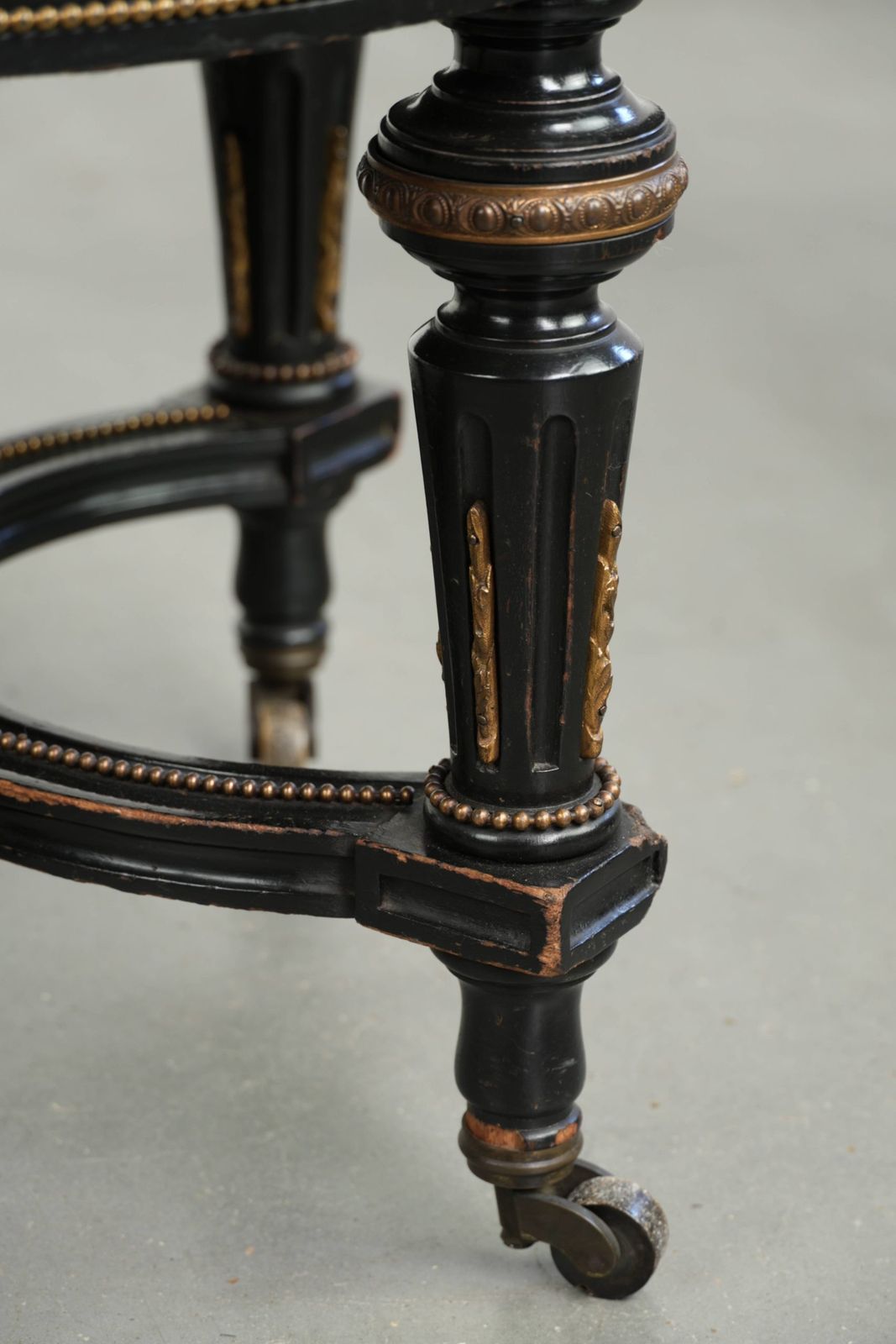 Meubels Antieke Engelse kruk met rode stoffen zitting en zwart houten onderstel met goudkleurige details photo