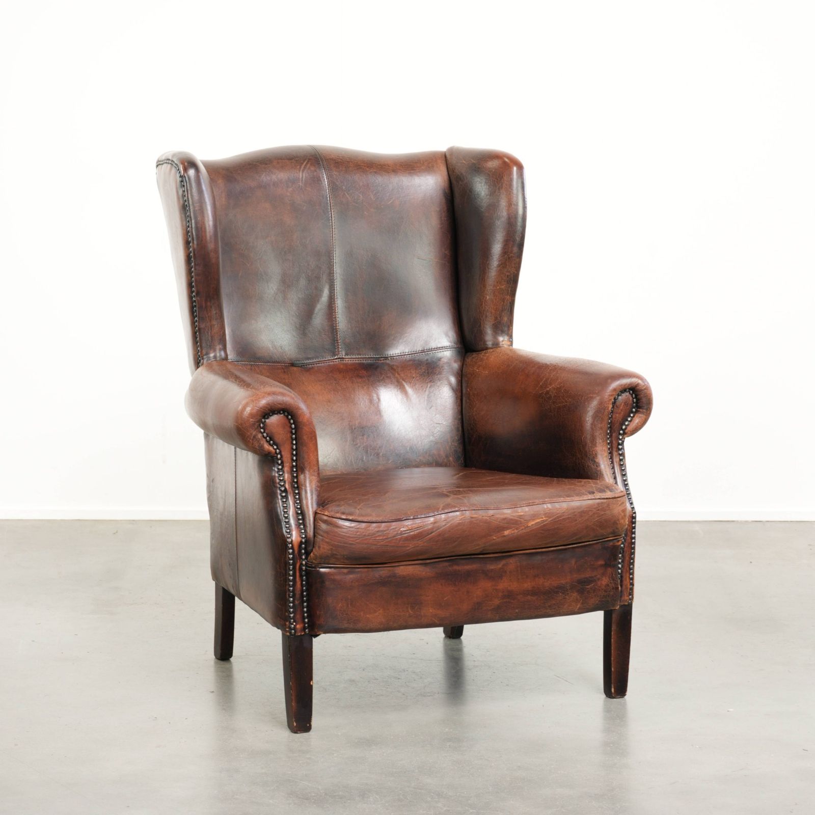 Ruime Vintage Schapenleren Oorfauteuil In Donkerbruin Met Siernagels
