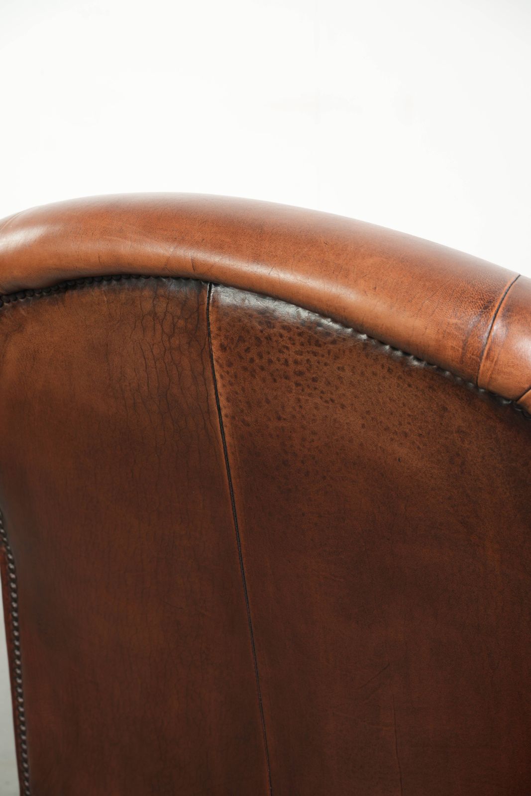 photo buy Vintage schapenleren fauteuil met comfortabele zitting en siernagels