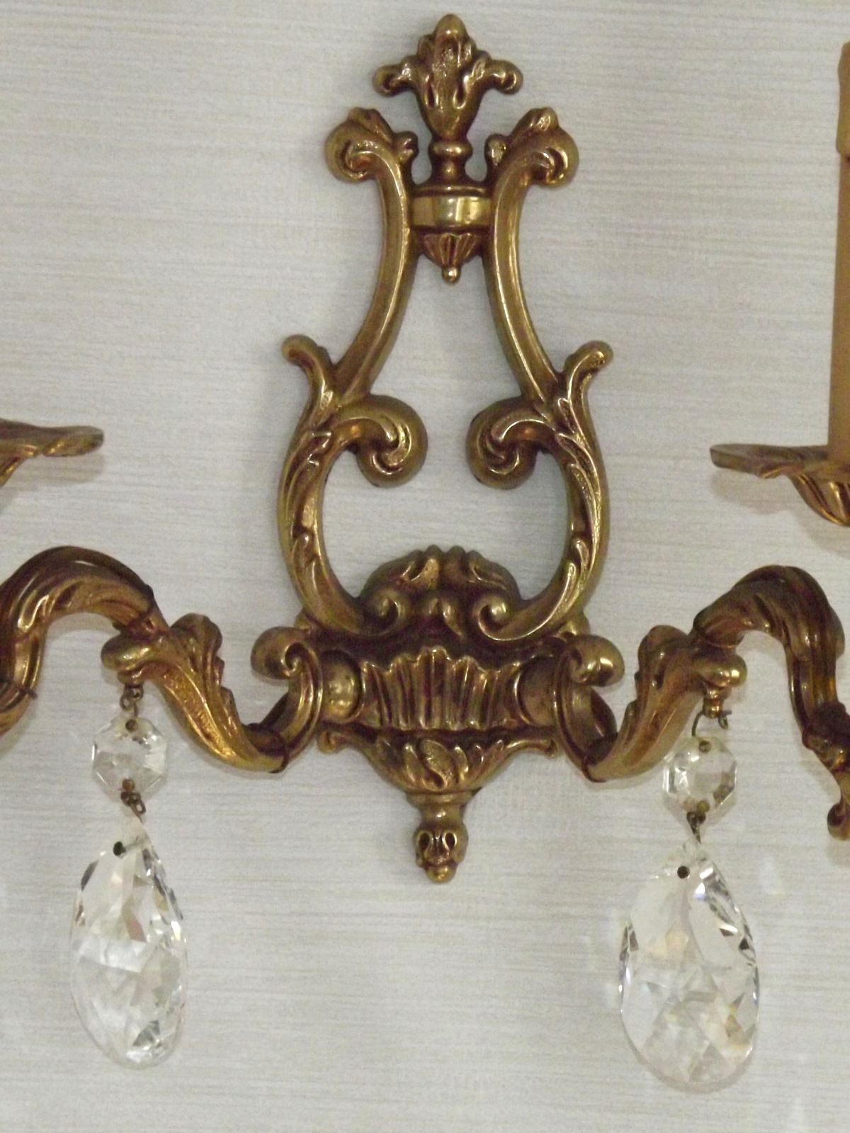photo furniture Paar Franse vintage wandlampen van gegoten brons en kristal met open achterkant
