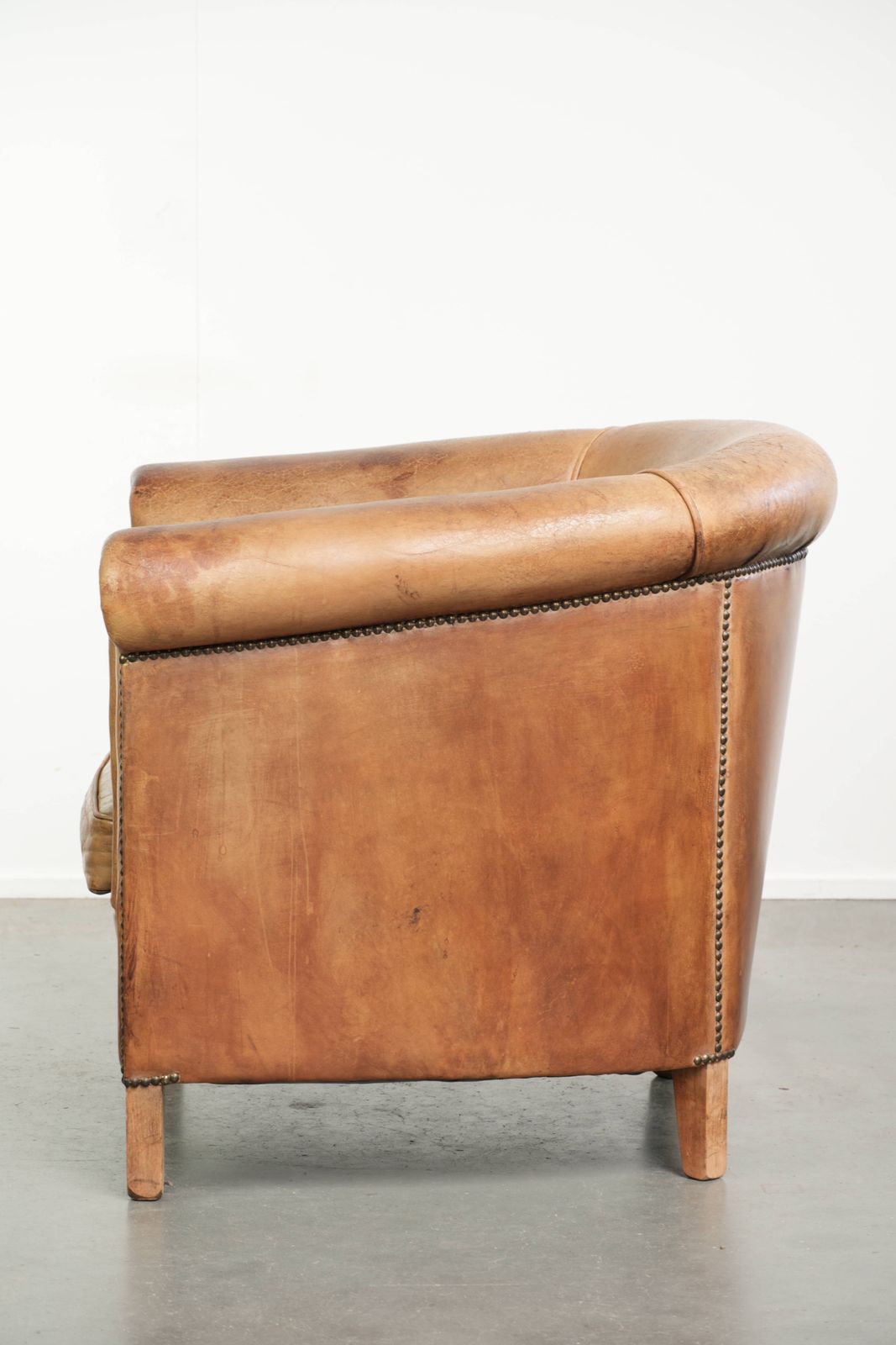 Stevige clubfauteuil in schapenleer, licht cognackleurig, afgewerkt met siernagels. photo 806.0