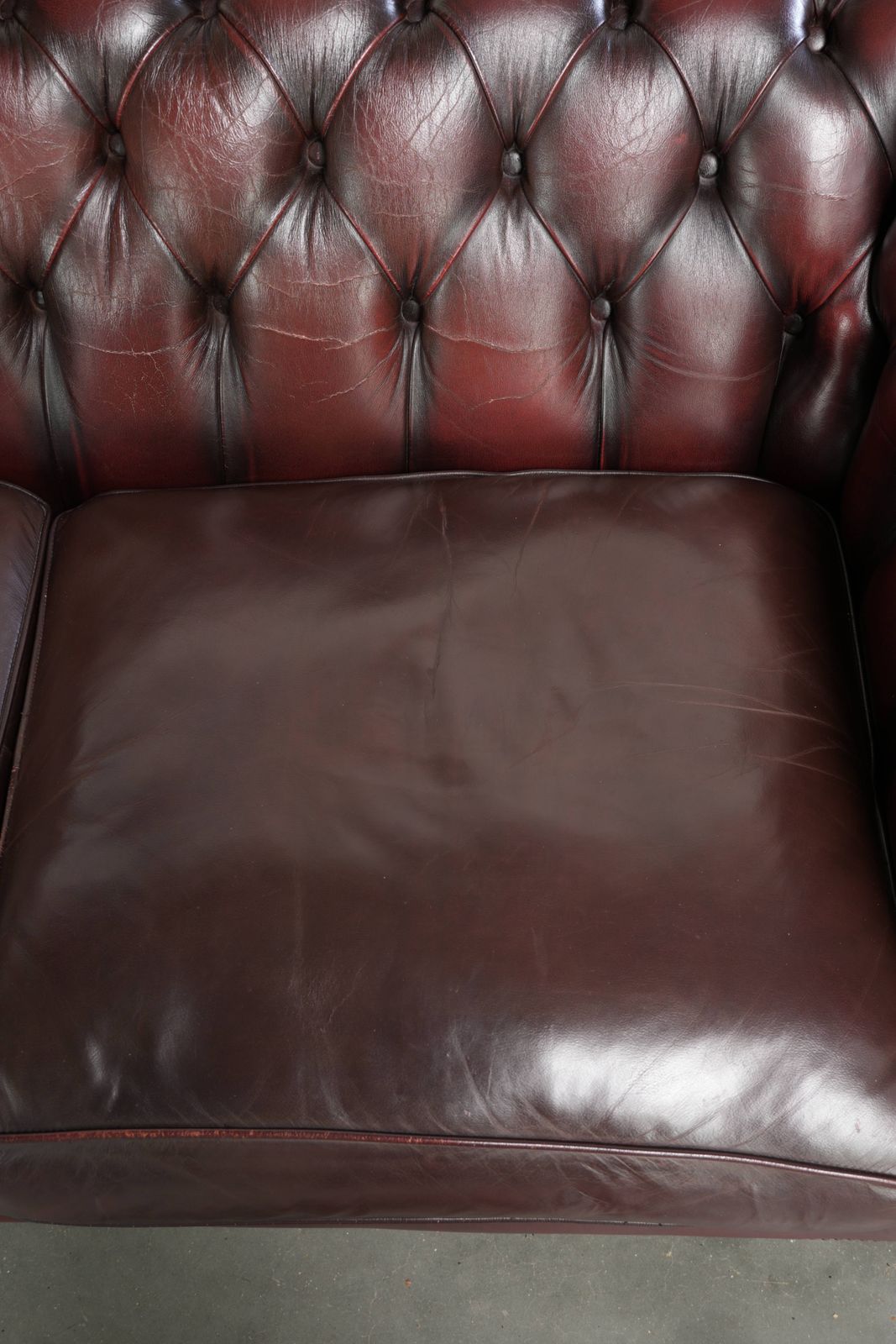 Tijdloze Chesterfield 2,5-zitsbank van koeienhuid in oxblood rood met mooie patina photo 1629.0