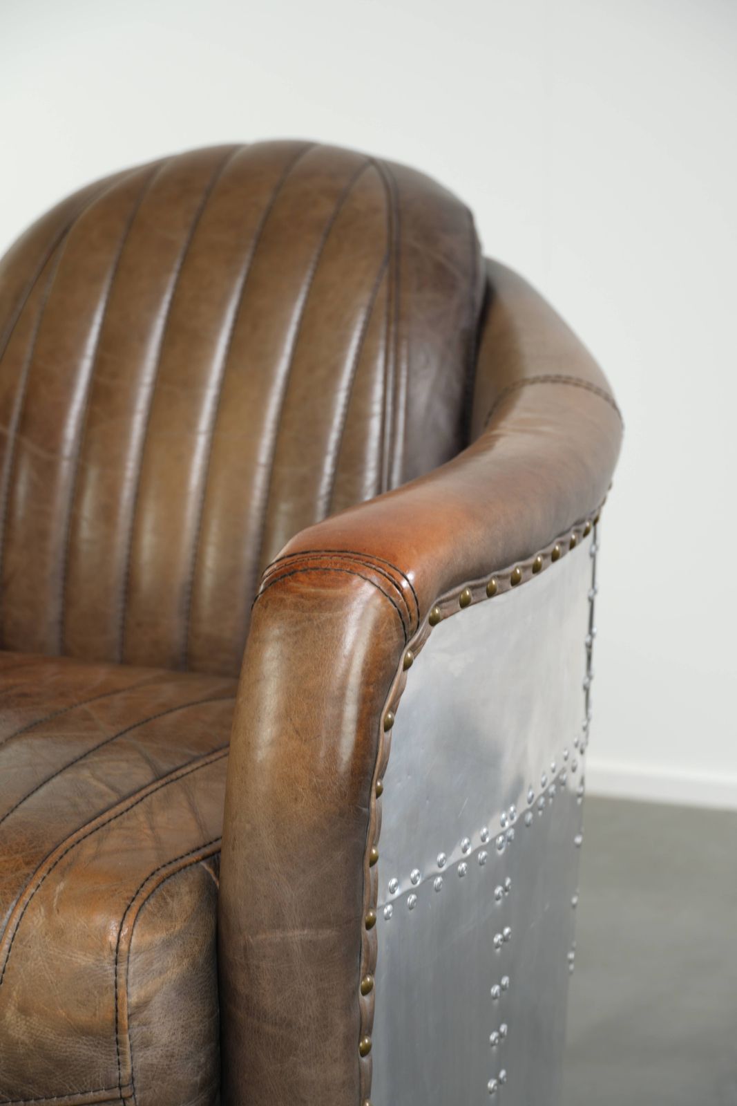 photo for sale Stoere en karaktervolle fauteuil in aviatorstijl van koeienhuid leer met een unieke aluminiumafwerking