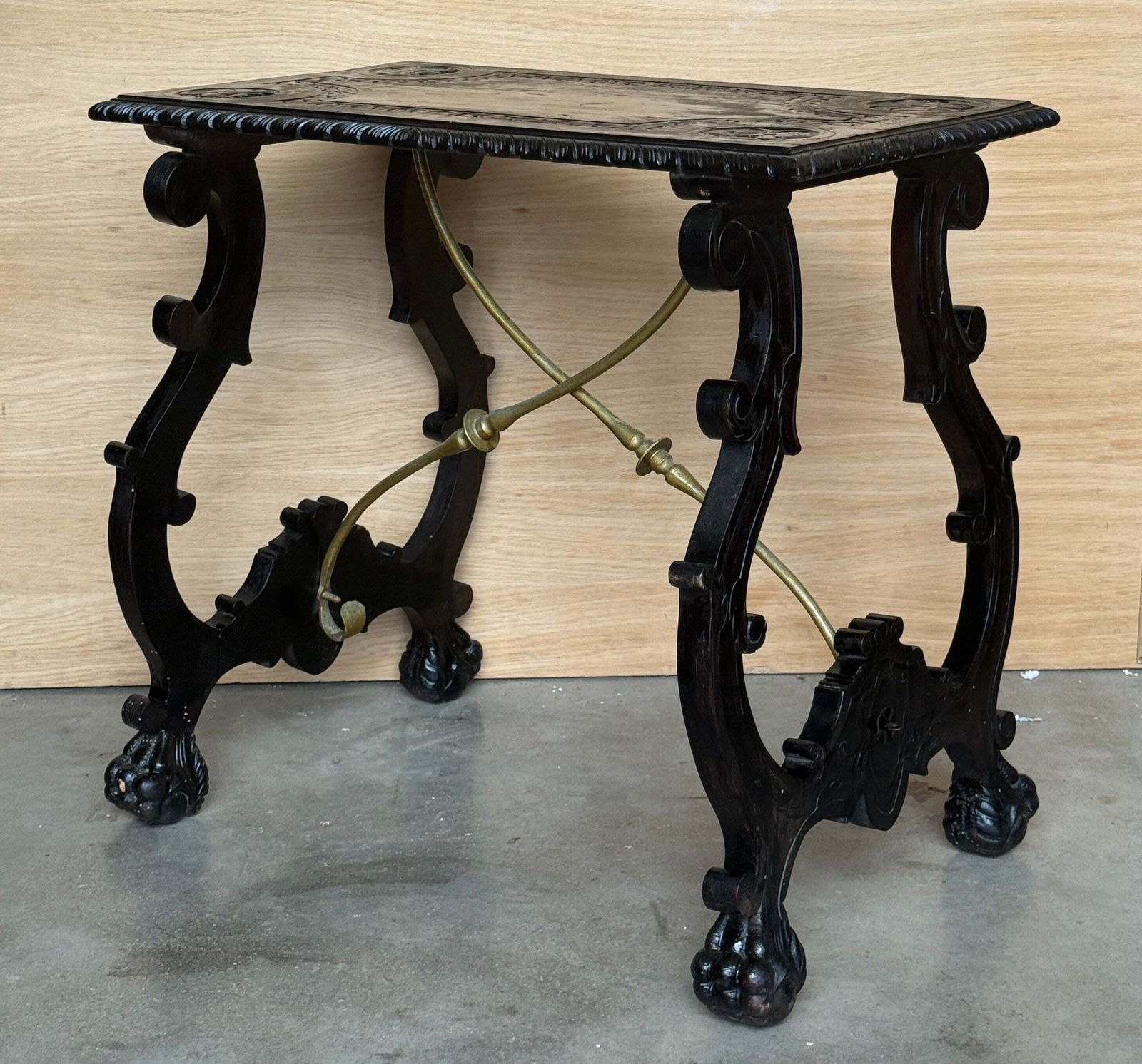 Table centrale d'époque en bois ébénisé sculpté, traverses en laiton et pieds en patte photo Mobilier
