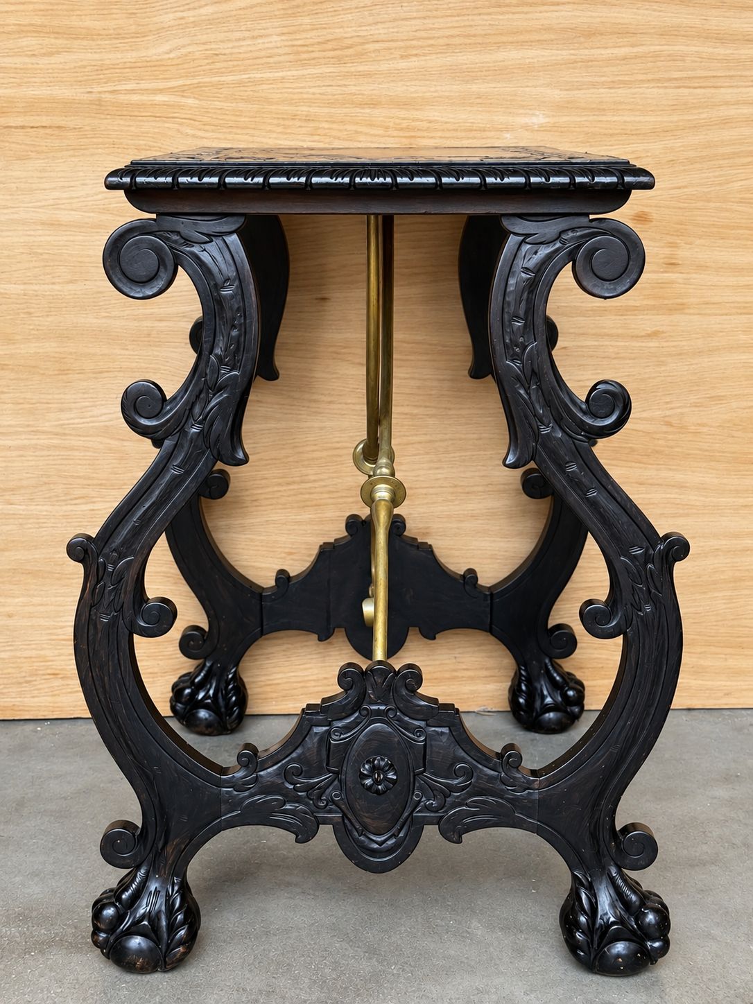 Table centrale d'époque en bois ébénisé sculpté, traverses en laiton et pieds en patte photo vinterior