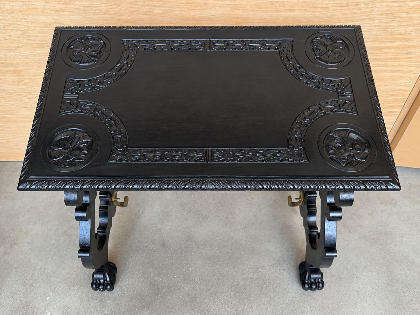 Table centrale d'époque en bois ébénisé sculpté, traverses en laiton et pieds en patte photo vintage