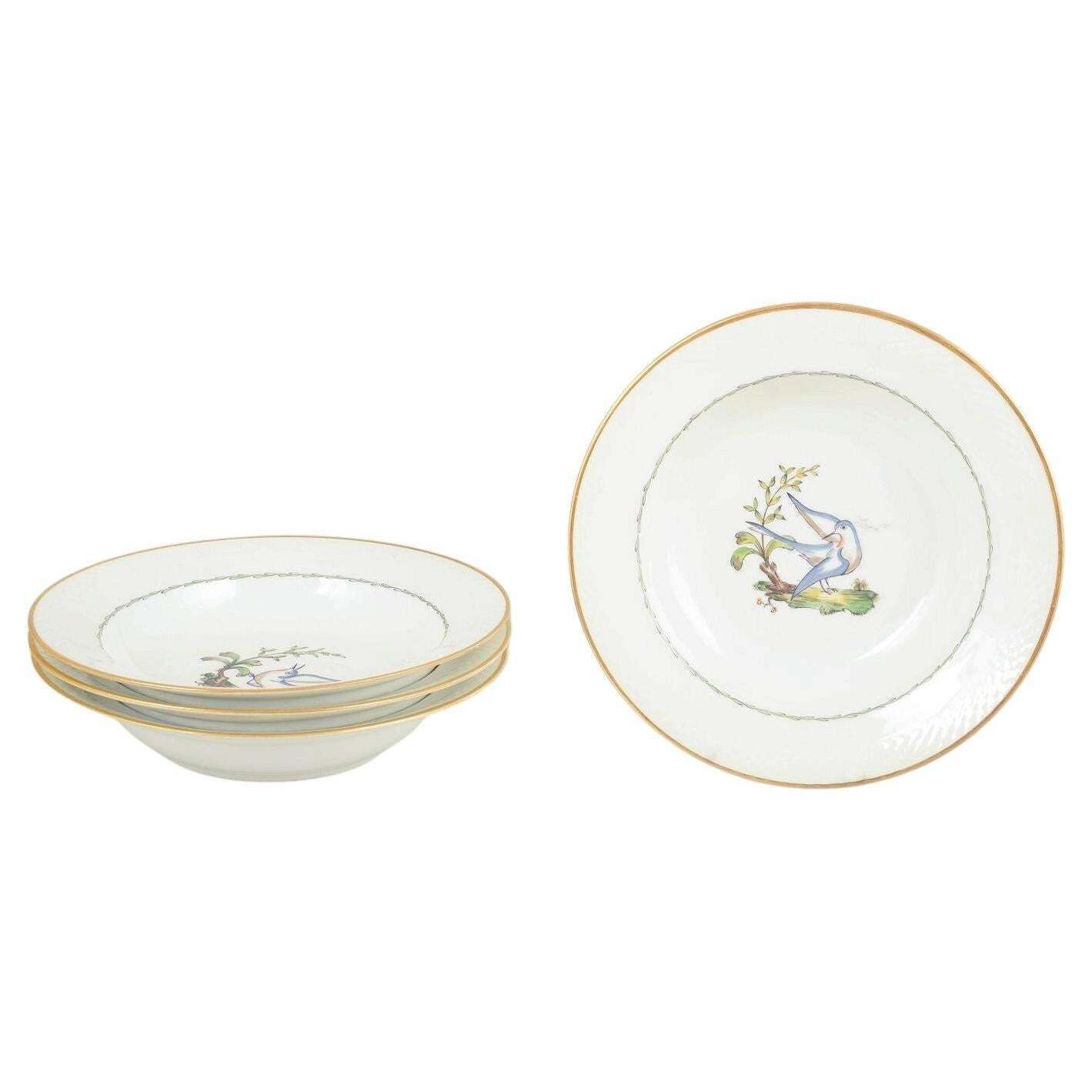 Royal Copenhagen. Ensemble de quatre grandes assiettes creuses à motifs d'oiseaux. Début du XXe siècle.