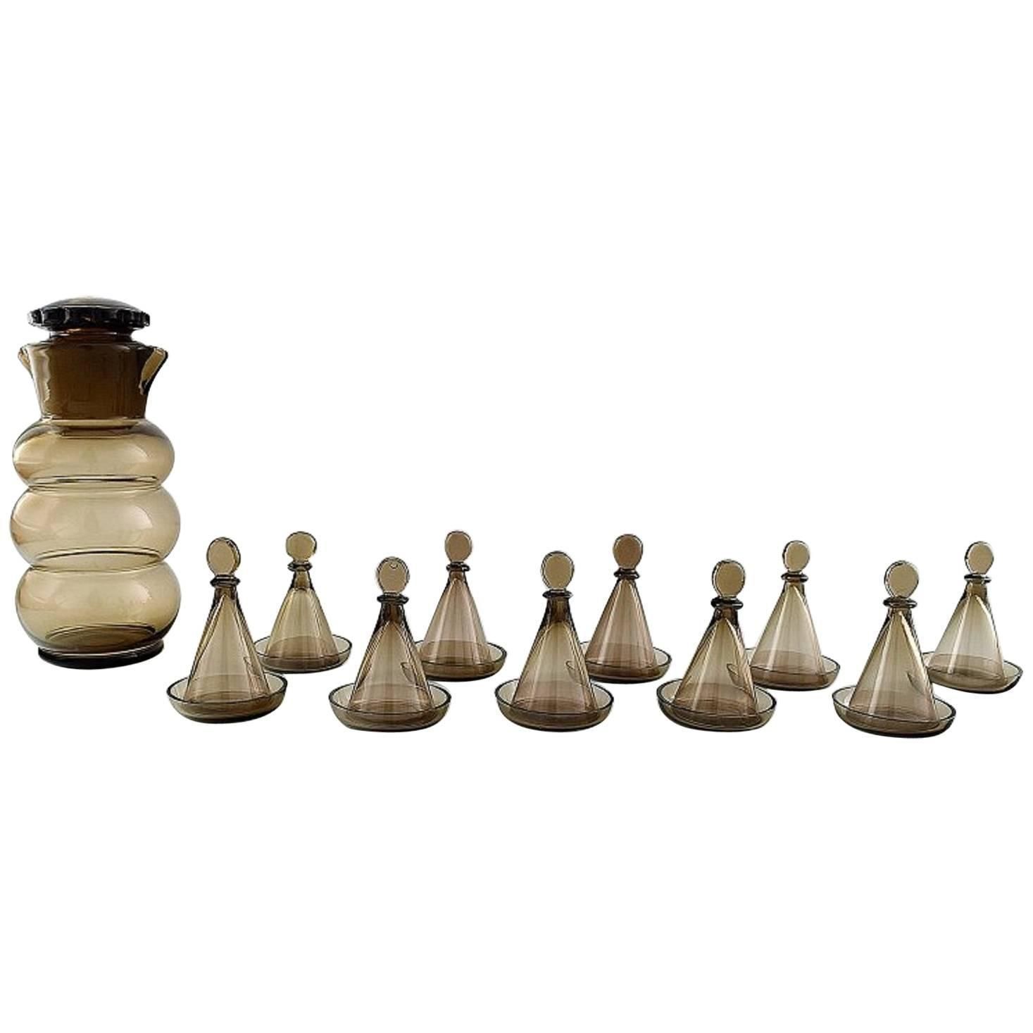 Jacob Bang: "Helan Går". Brown Glass Decanter And Ten Schnapps Glasses