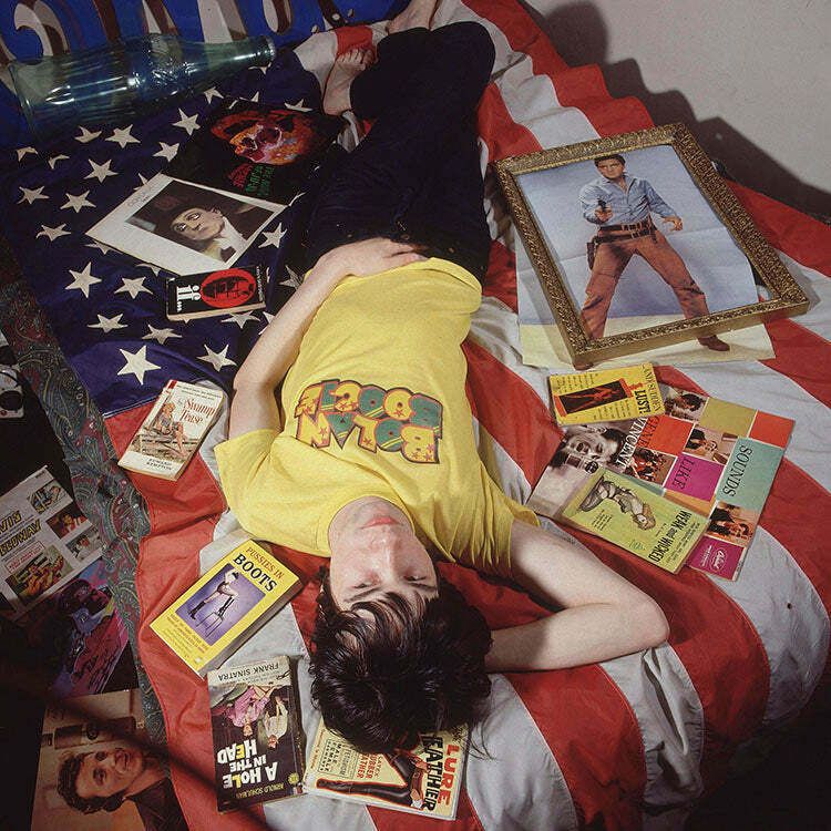 Singer And Songwriter Bobby Gillespie Of Scottish Rock Group Primal Scream, Photographed Lying On A Bed Surrounded By Paraphernalia