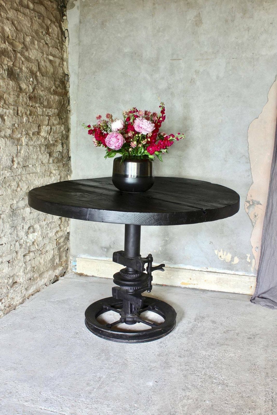 Shift Reclaimed Chunky Scorched Timber Circular Table With A Heavy Pedestal Base Made Out Of An Old Gear System