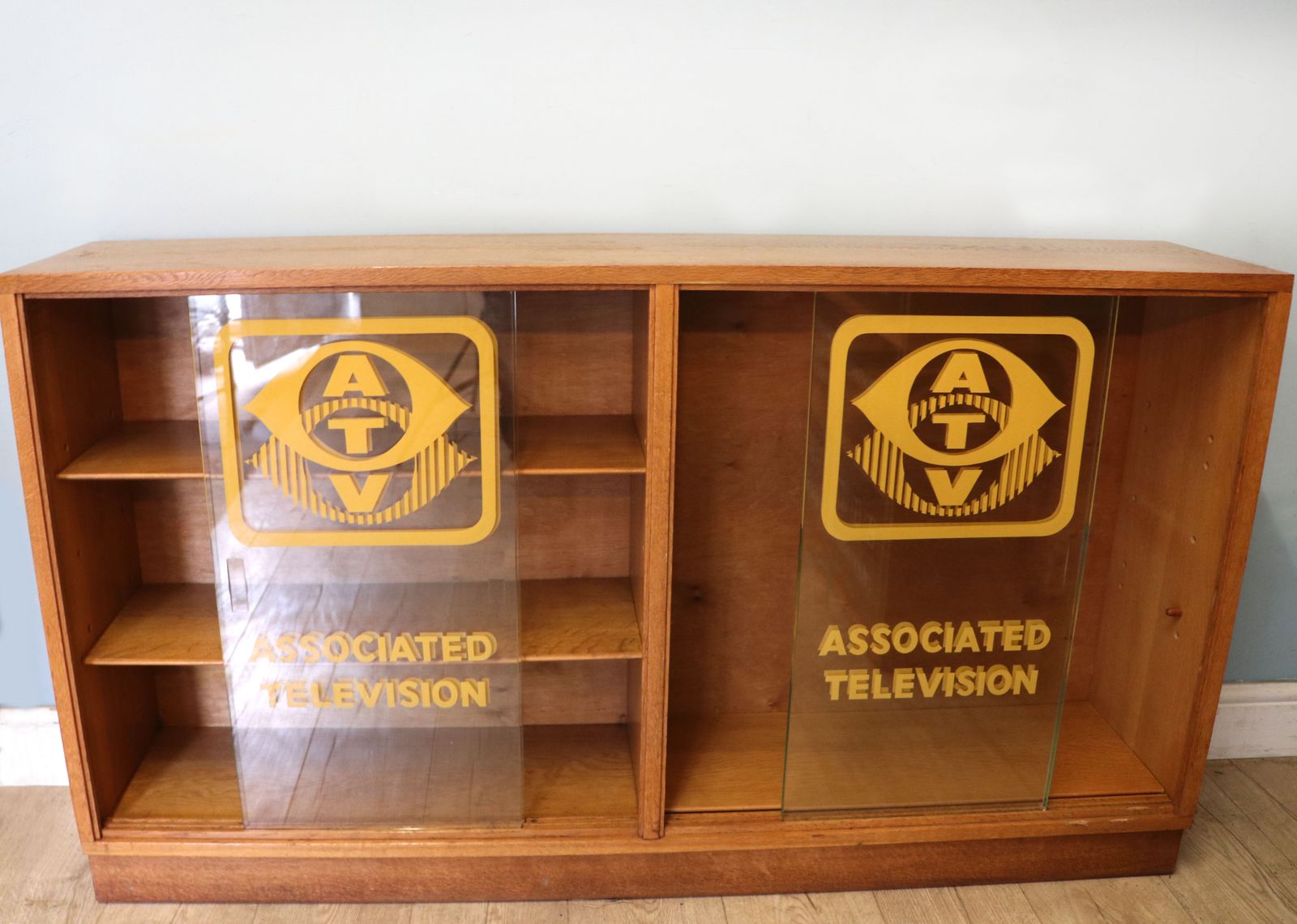A Mid Century Oak Bookcase Cabinet, Later Sign Written For Associated Television. photo furniture