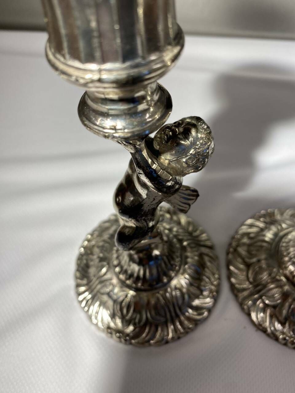 photo for sale Two Silver Metal Candlesticks Decorated With 20th Century Cherubs