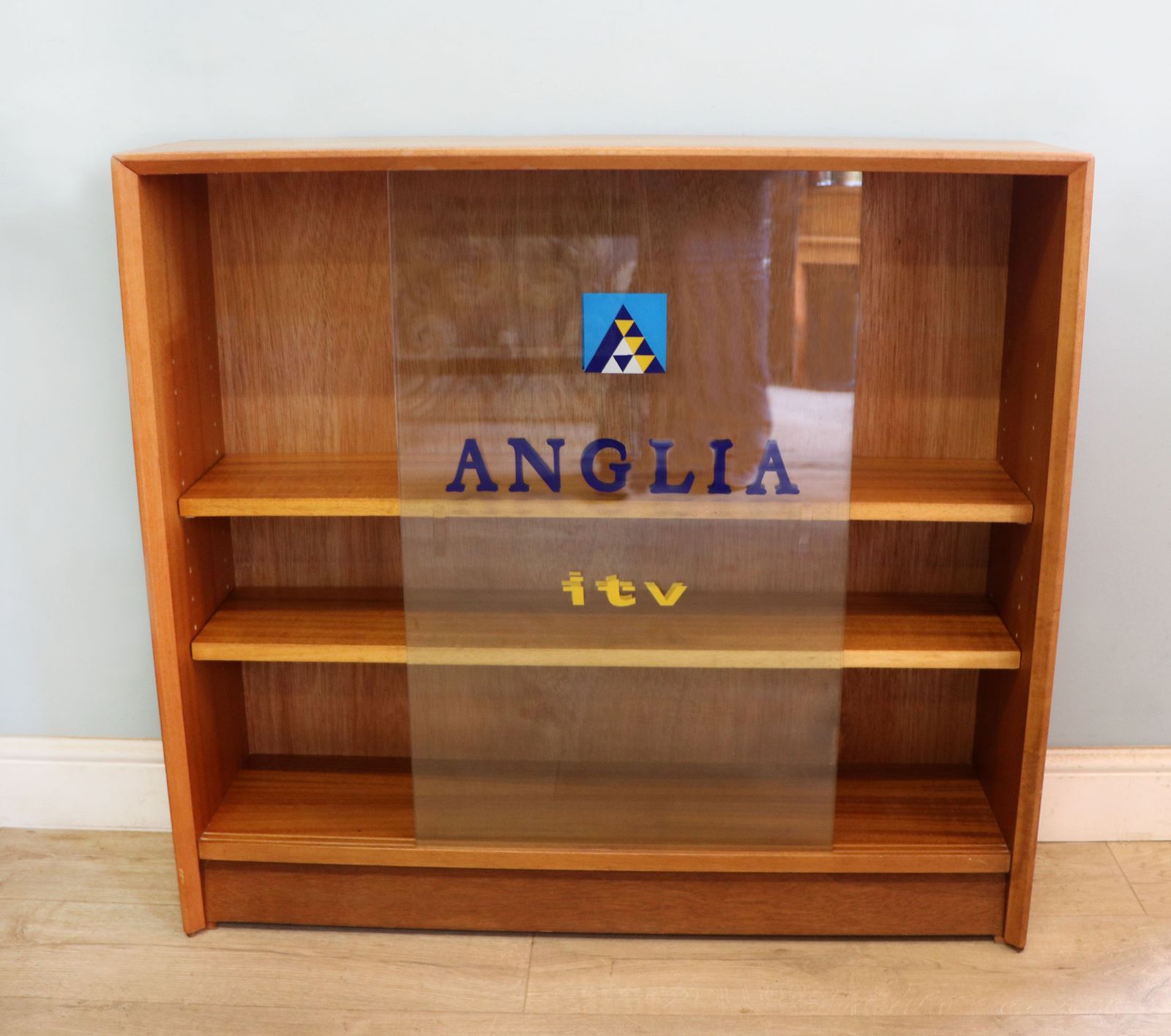 A Mid Century Gibbs Display Cabinet With The Anglia Television Logo. photo furniture