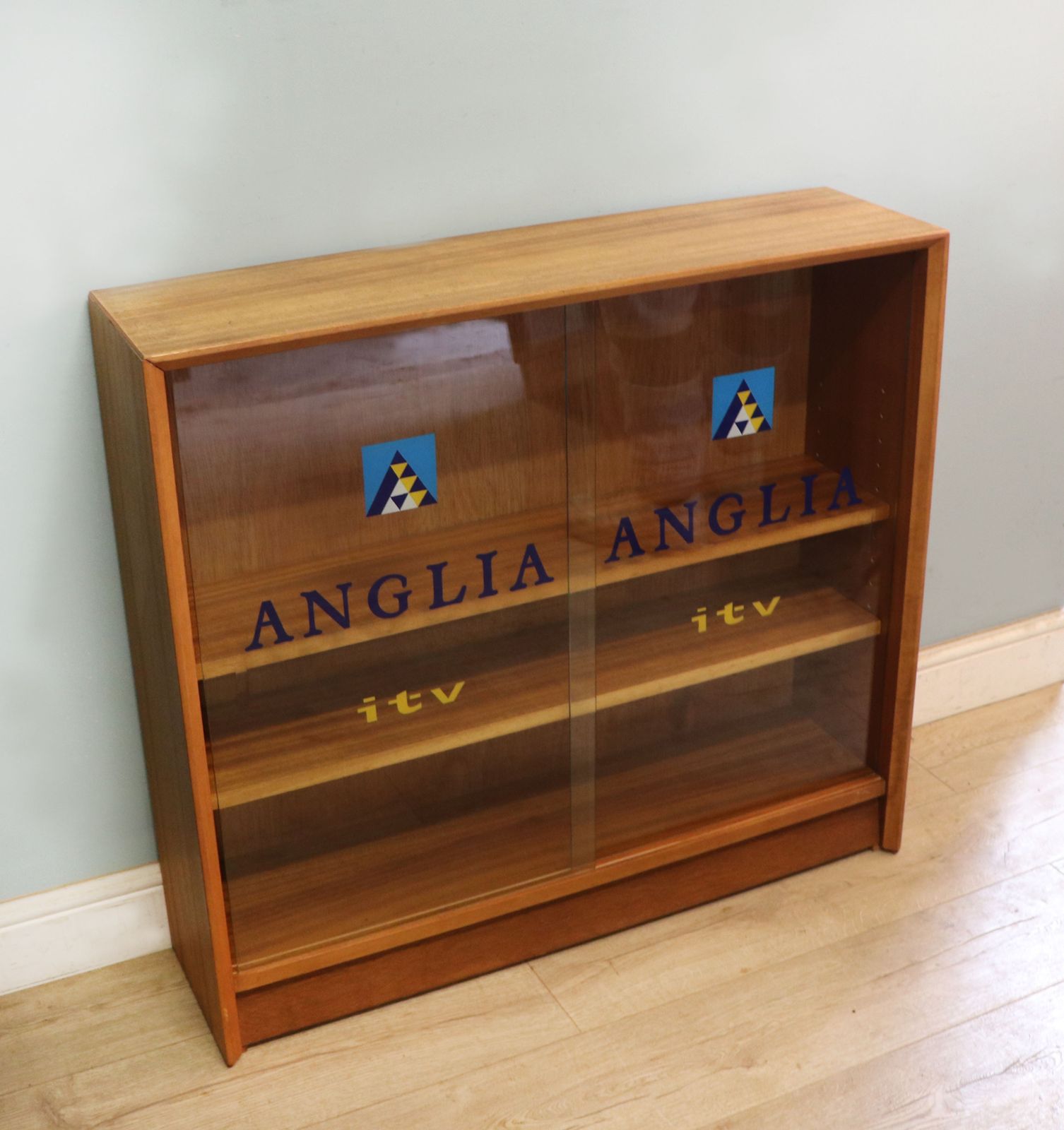 A Mid Century Gibbs Display Cabinet With The Anglia Television Logo. photo Furniture