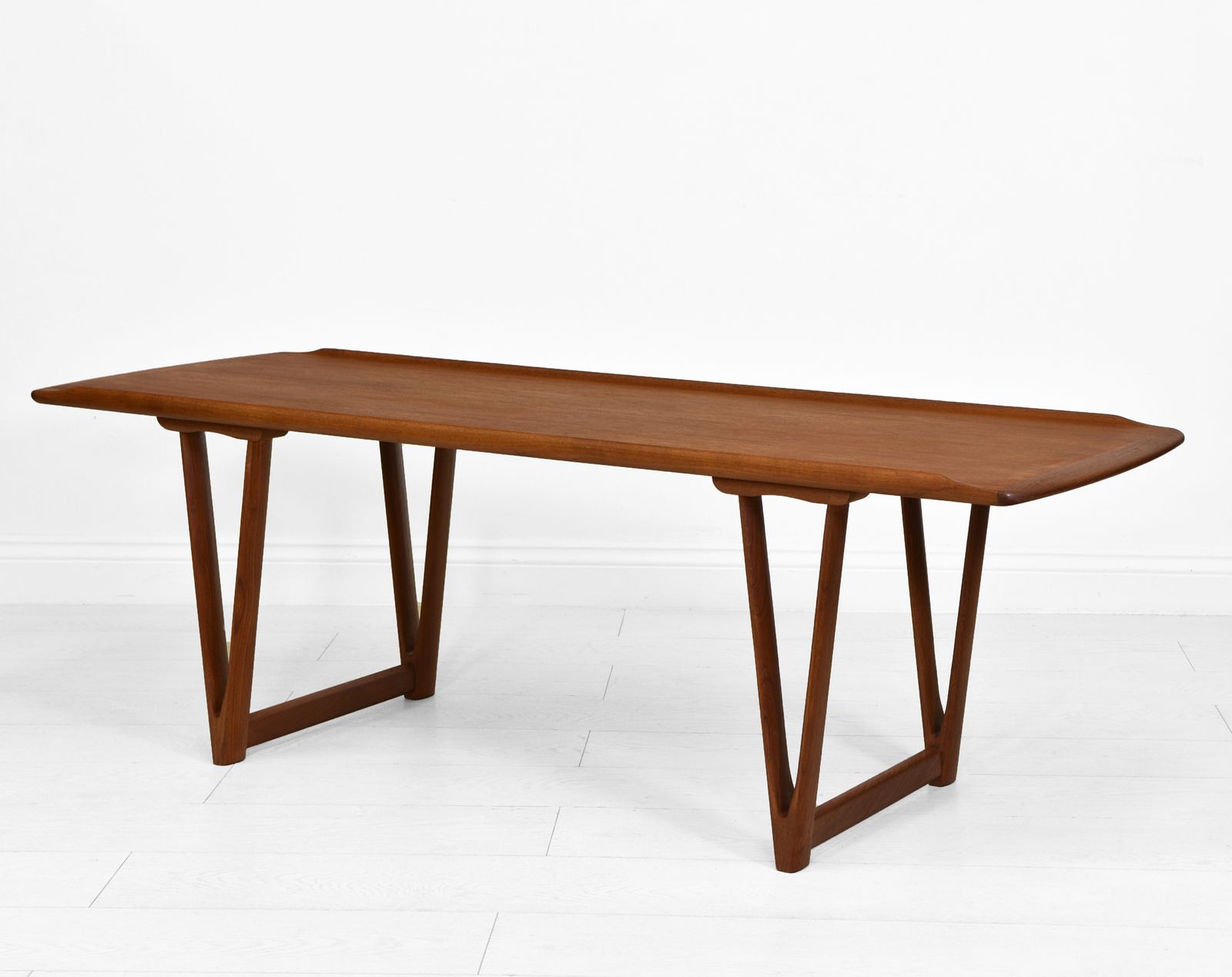 Mid Century Danish Teak Coffee Table On V Shape Supports And Lipped Top Edge photo furniture