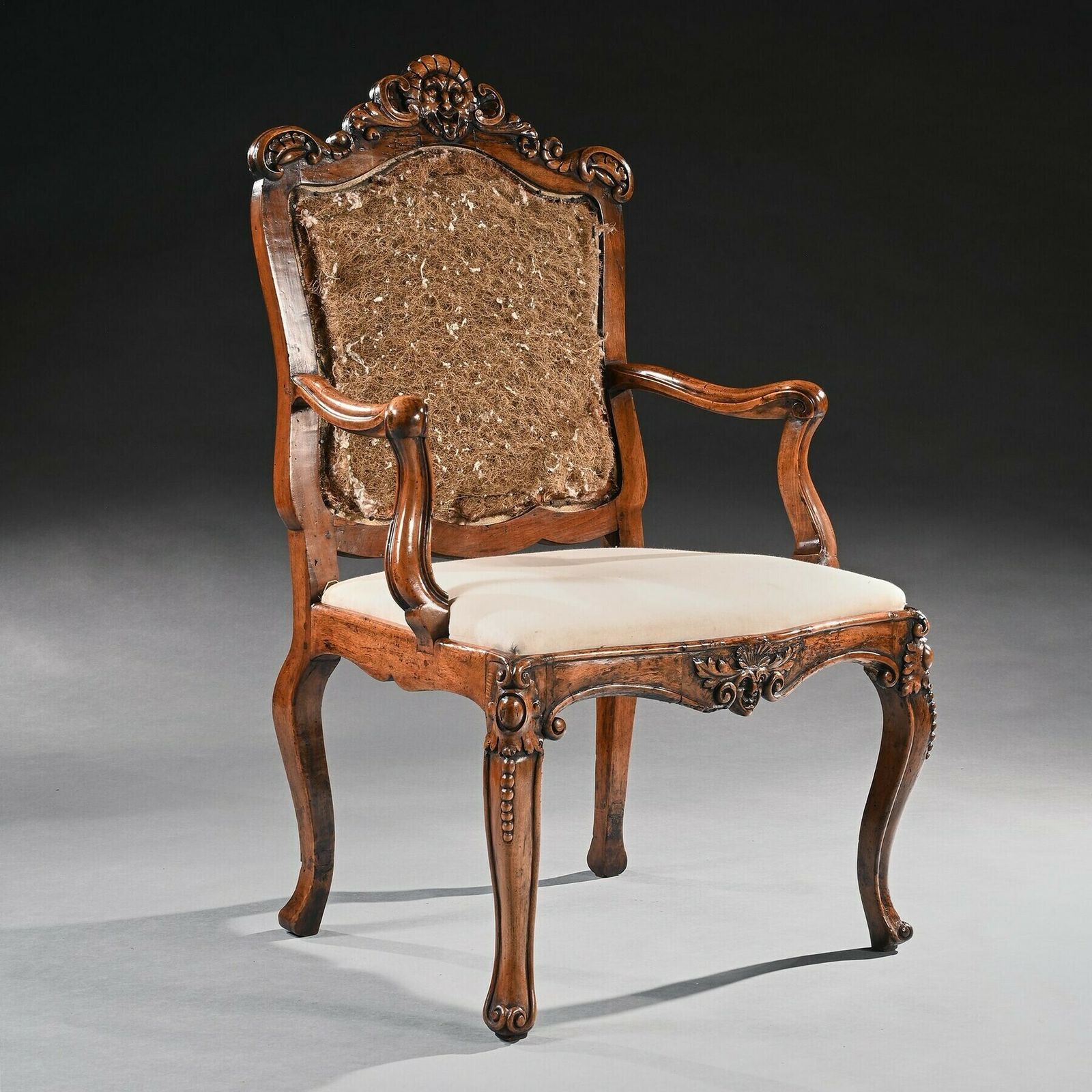 Mid 18th Century Italian Rococo Armchair In Walnut With Extravagantly Carved Head Rail