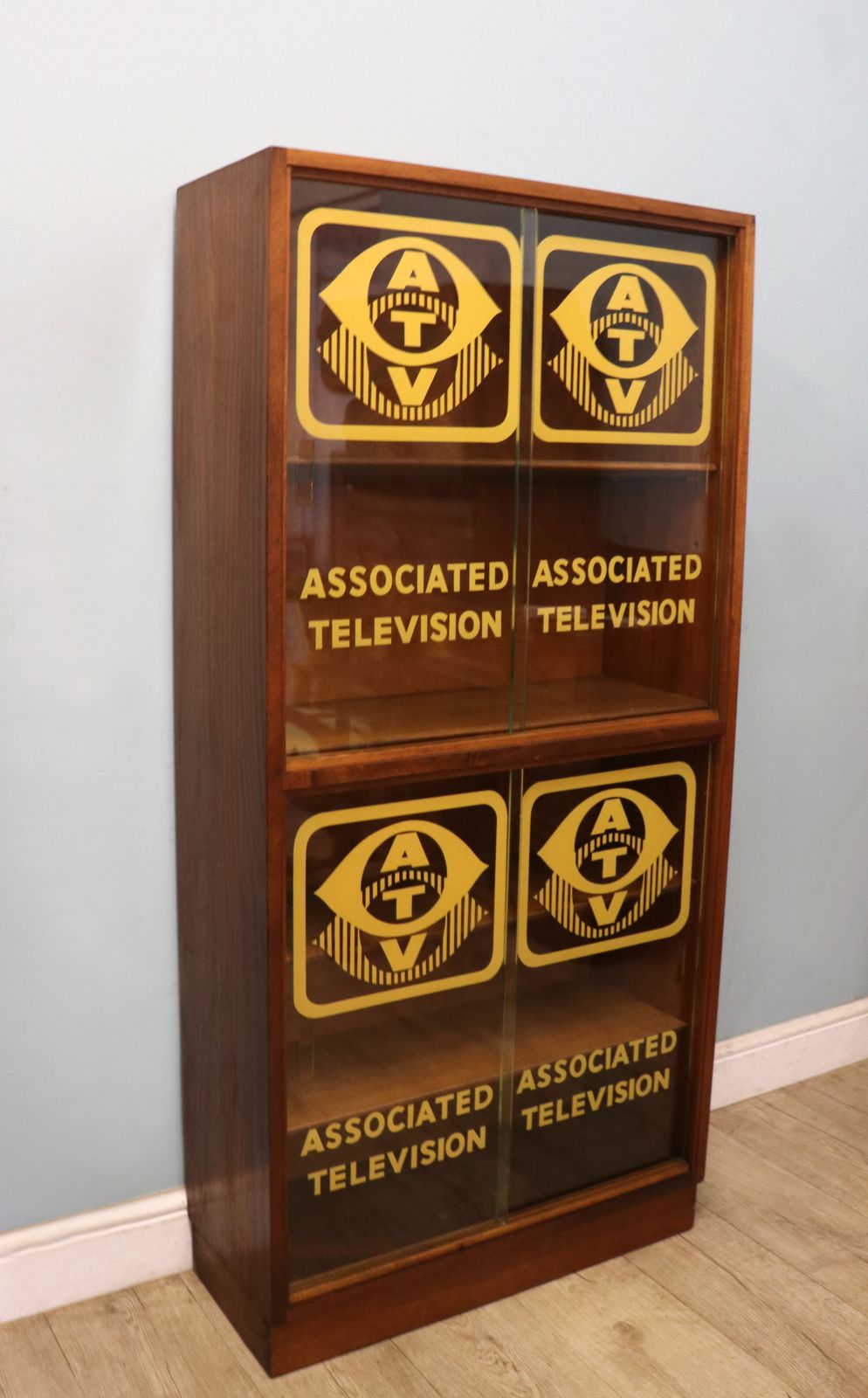 A Lovely Mid Century Display Cabinet Later Sign Written With The Emblems And Wording For Associated Television. photo for sale