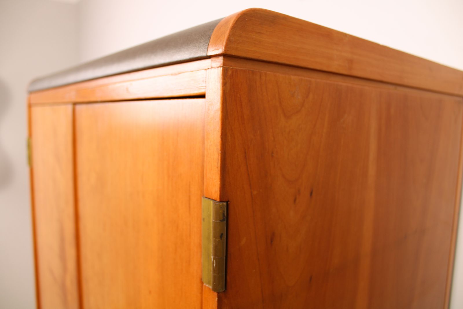 A Vintage Mid Century Cupboard, With Faux Leather Top And Recessed Metal Handles photo vinterior