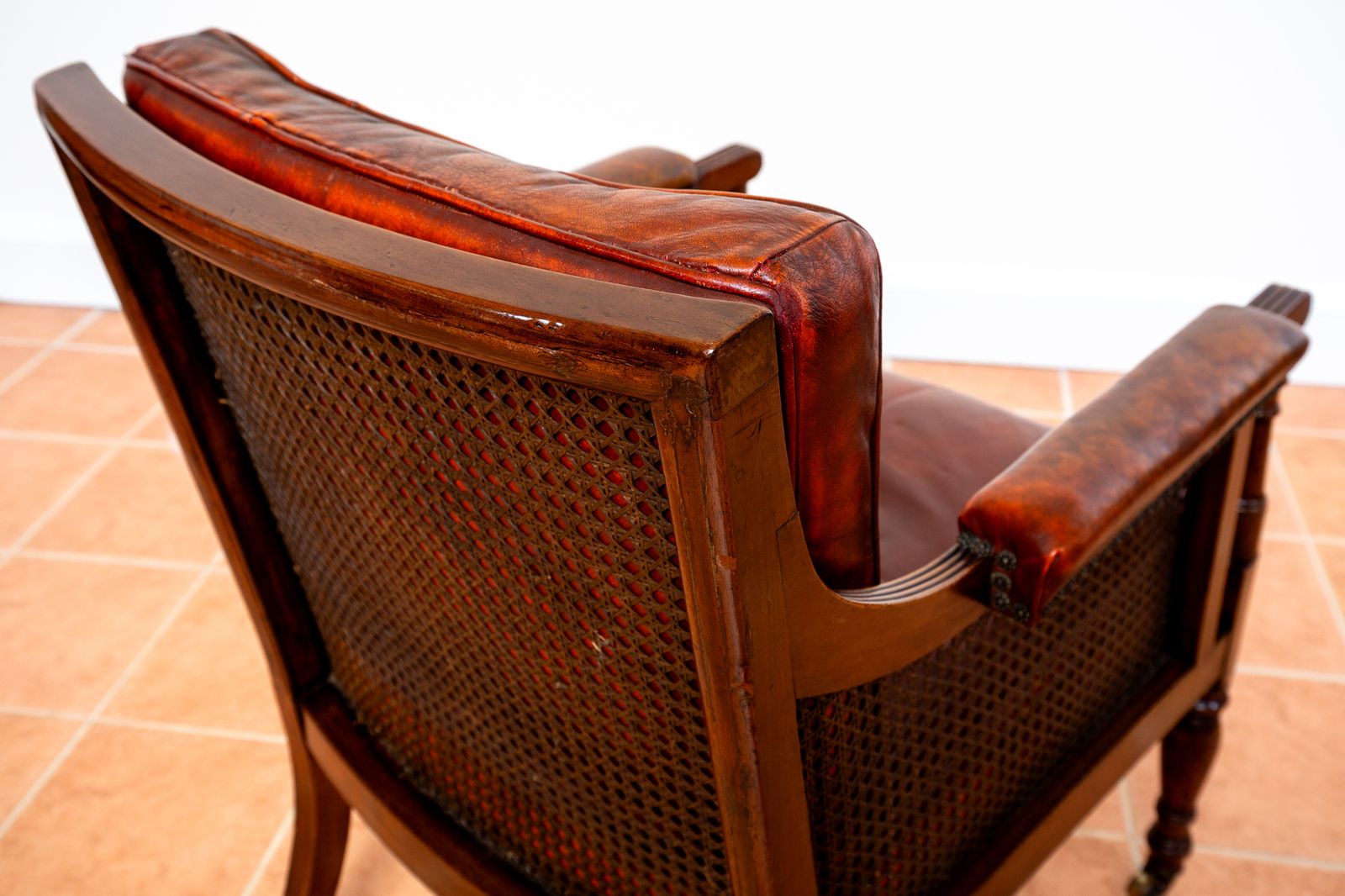 photo buy Fine Regency Bergere Leather Library Chair 1810 1820 Georgian Reading Red Leather Armchair Carved Cane Rattan Brass Castors