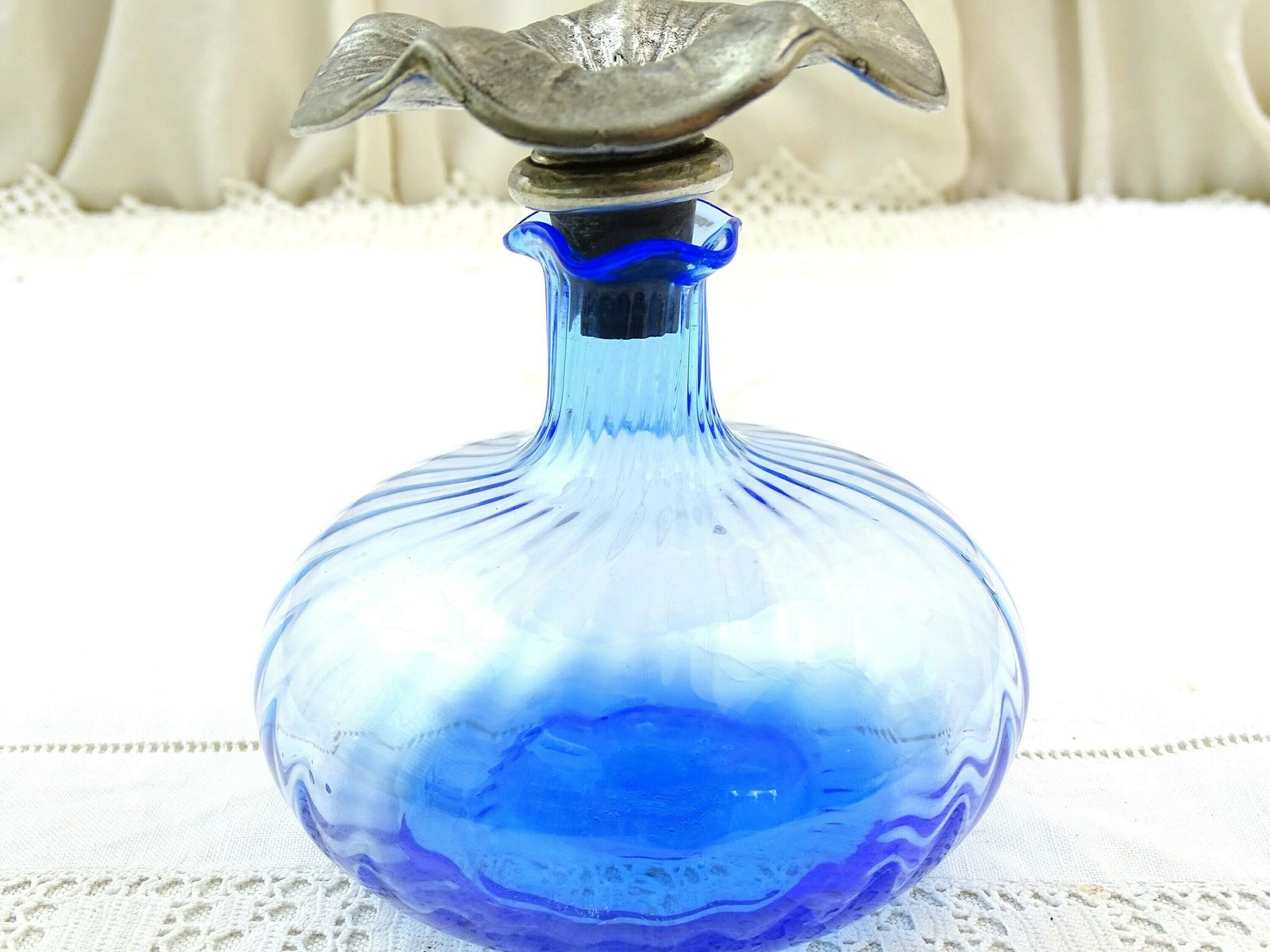 Flacon d'eau de cologne vintage en verre bleu, bouchon fleur en étain, France photo vintage