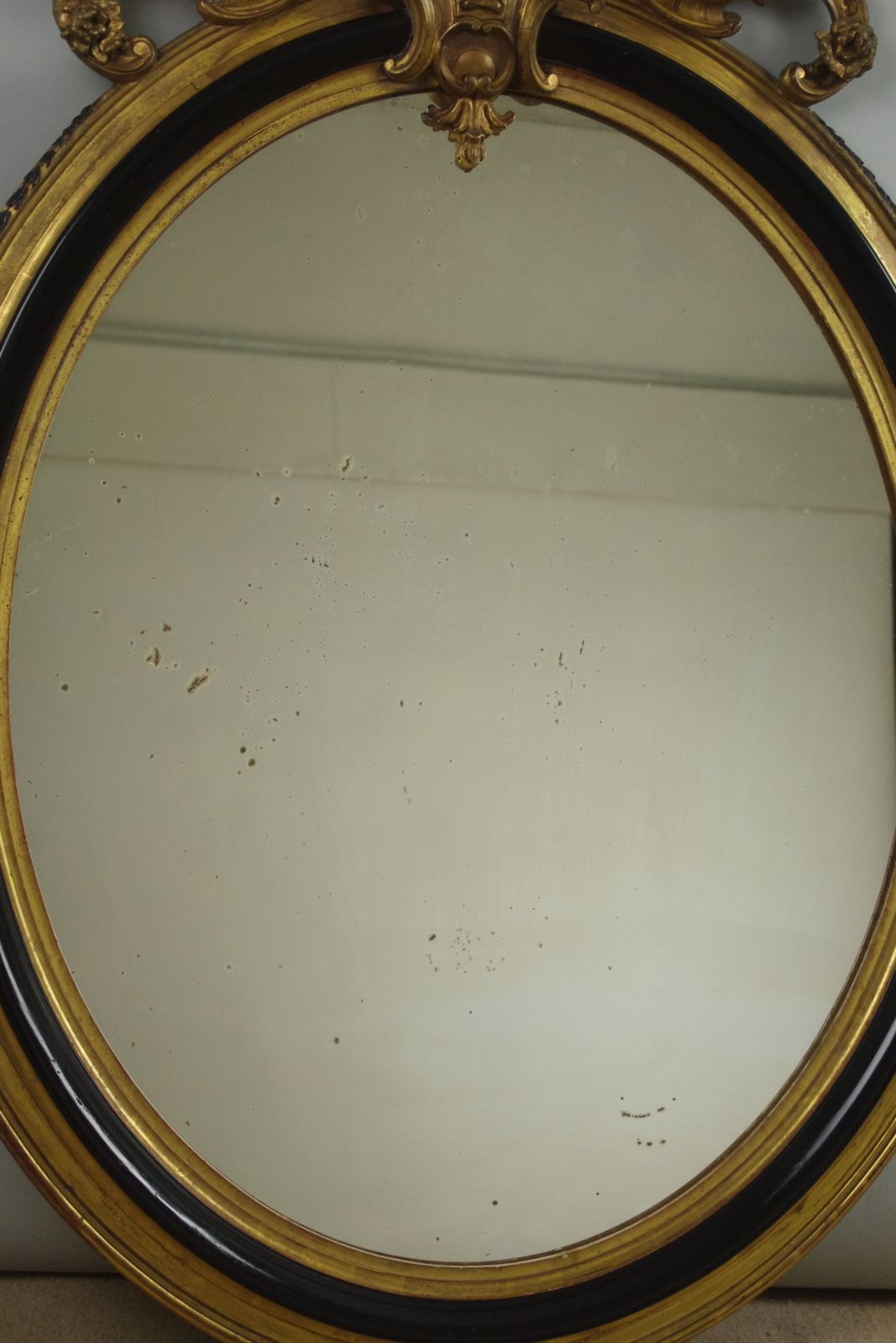 photo furniture 19th Century French Ebonised And Parcel Gilt Large Oval Wall Mirror