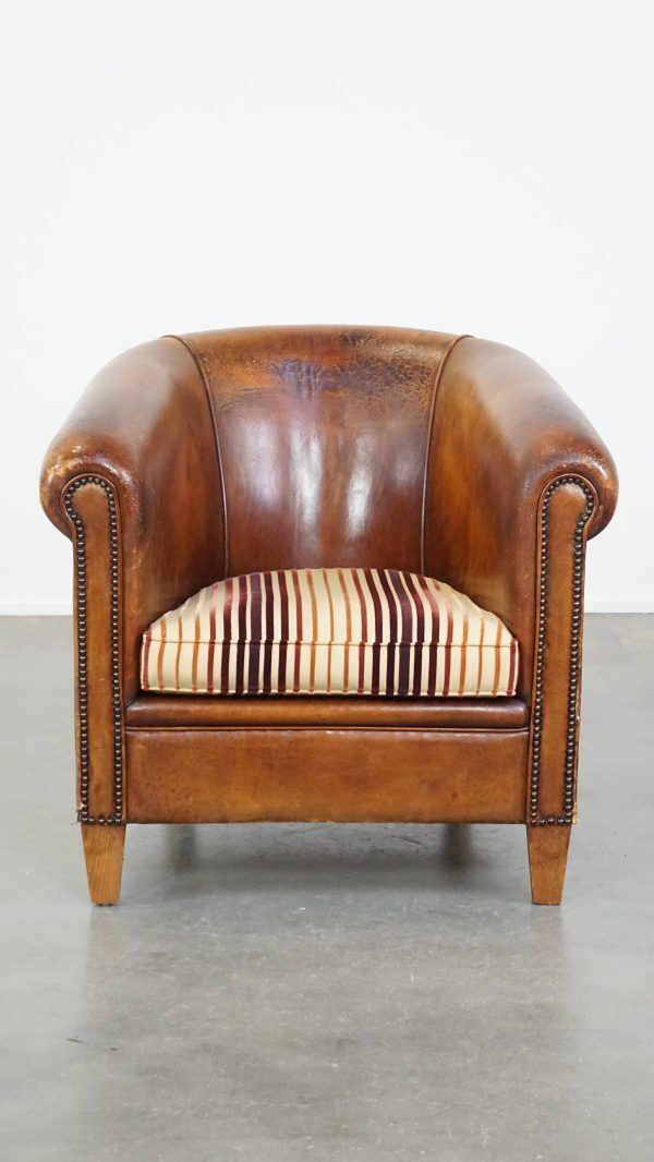 Characterful Vintage Cognac Colored Club Chair Made Of Sheepskin With A Colorful Fabric Seat Cushion photo furniture