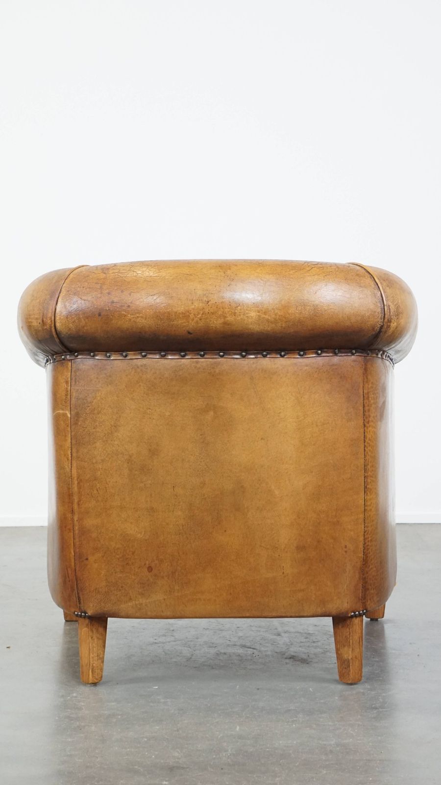 Characterful Vintage Cognac Colored Club Chair Made Of Sheepskin With A Colorful Fabric Seat Cushion photo Furniture