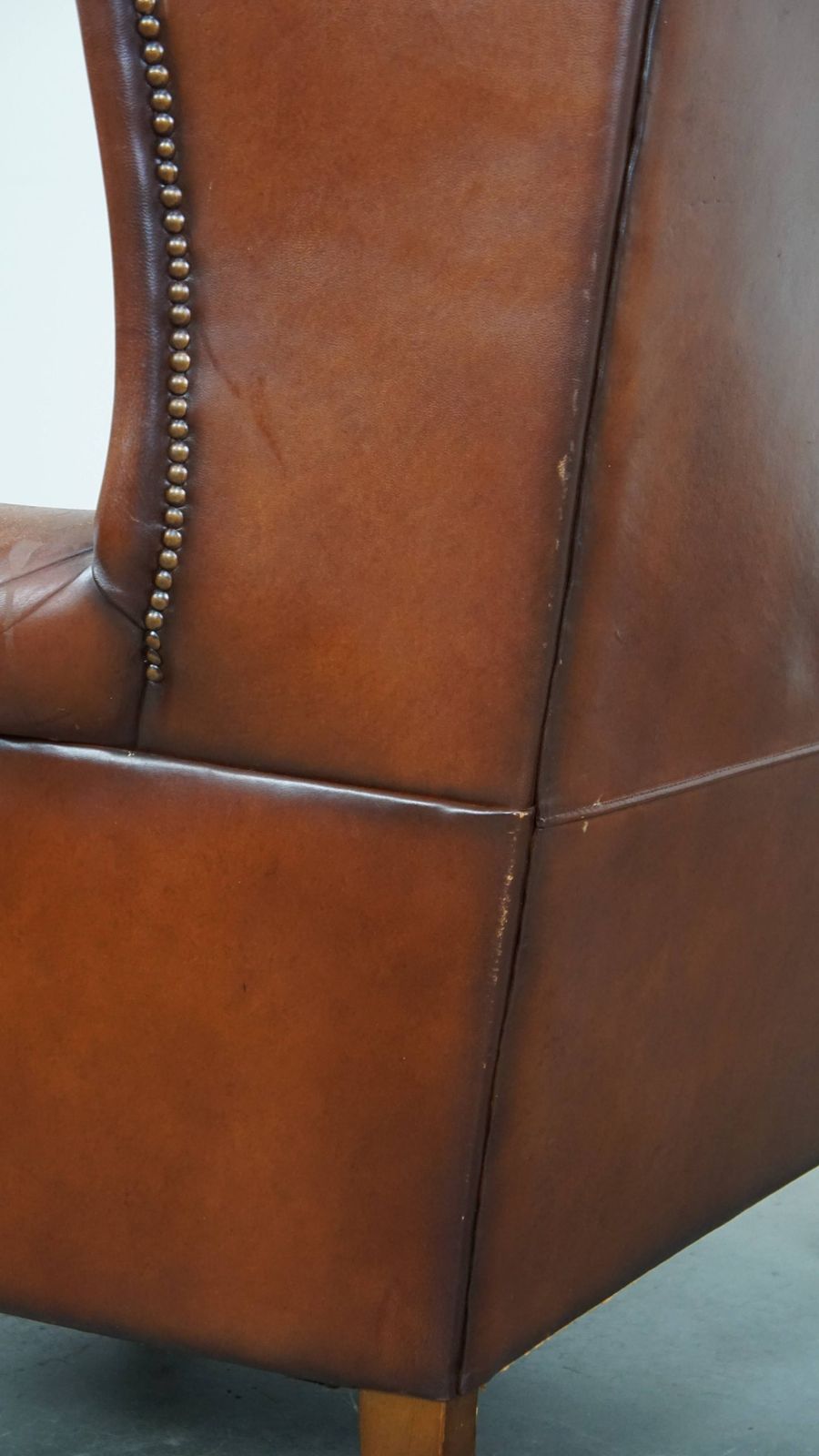 Furniture Comfortable Sheepskin Wing Chair With A Warm Color Scheme And A Beautiful Patina photo