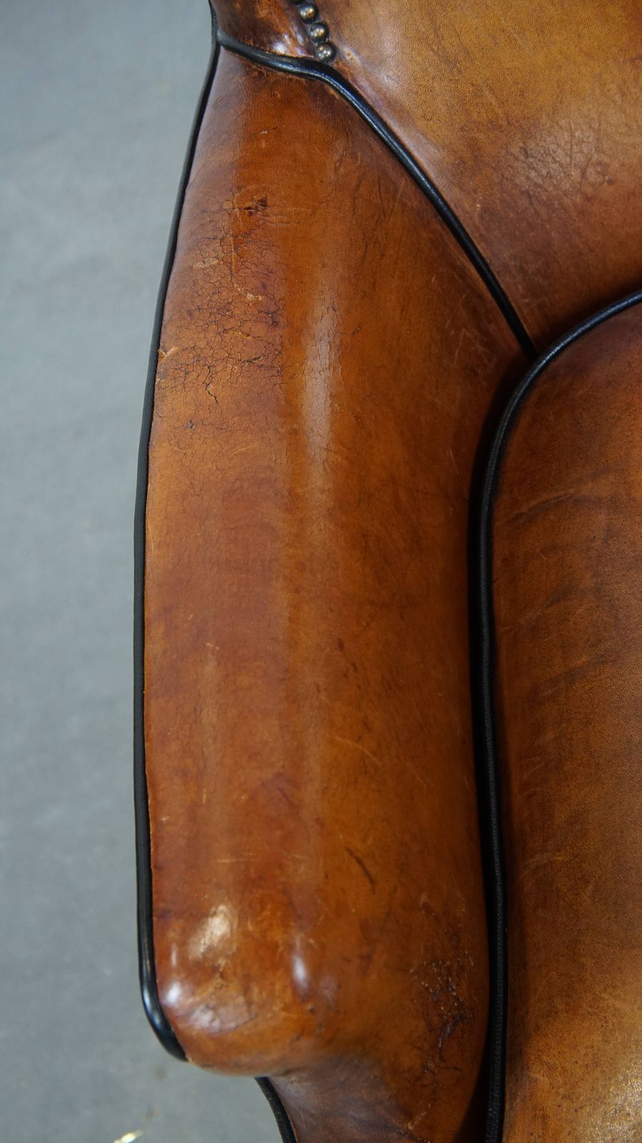 Subtle Cognac Colored Sheepskin Armchair With A Nice Design And Finish With Black Piping And Decorative Nails photo buy