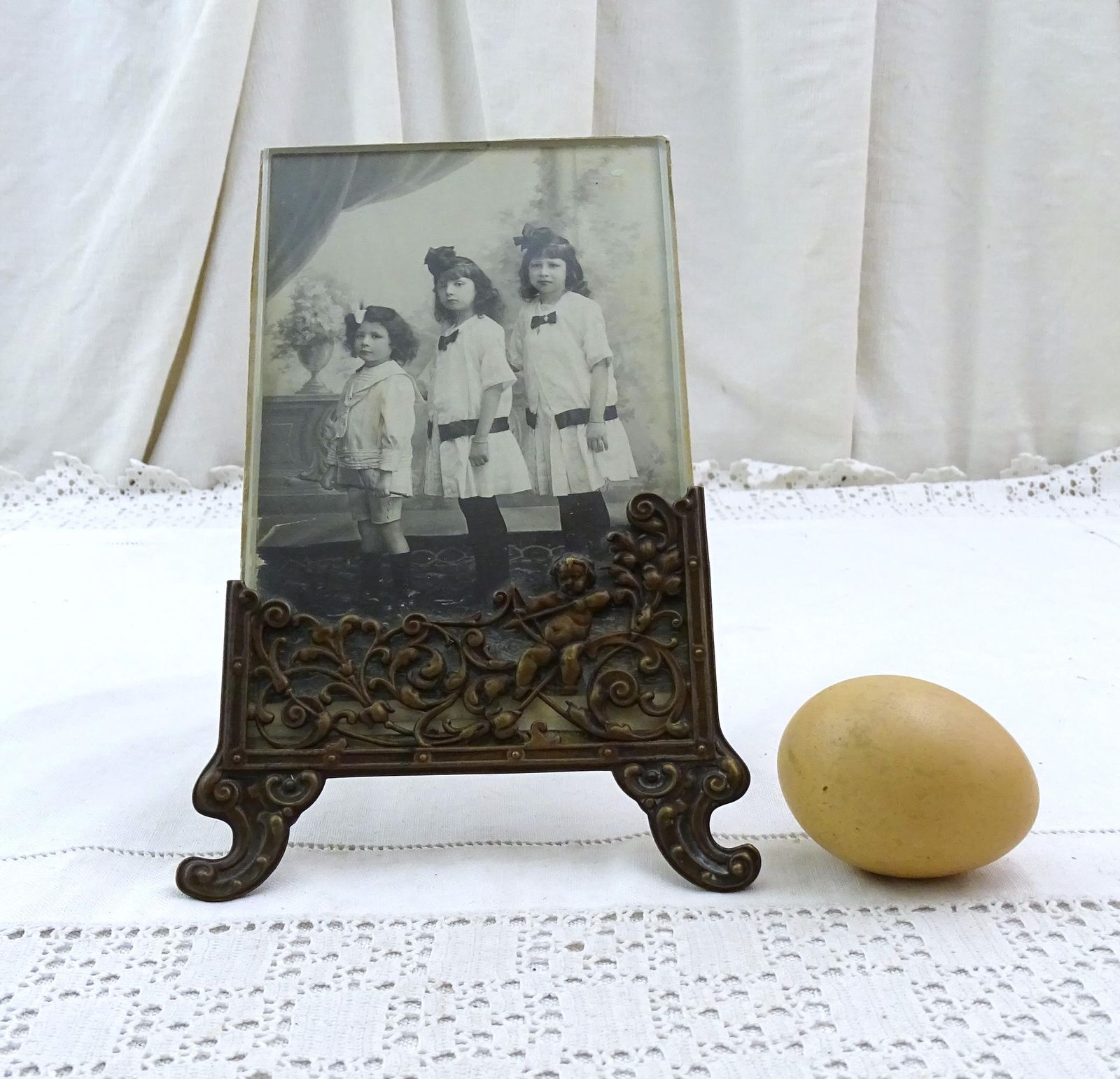 Antieke Franse Vrijstaande Fotolijst Met Cherub In Bronskleurig Reliëfmetaal En Zwart Witfoto Van Zusjes En Broertje photo buy
