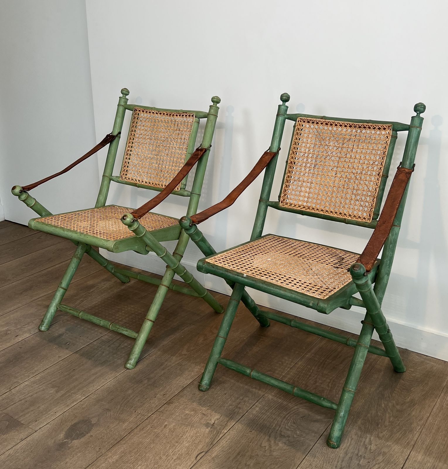 1450.0 Pair Of Folding Safari Chairs In Weathered Faux Bamboo Style With Caned Backs And Seats And Leather Armrests photo