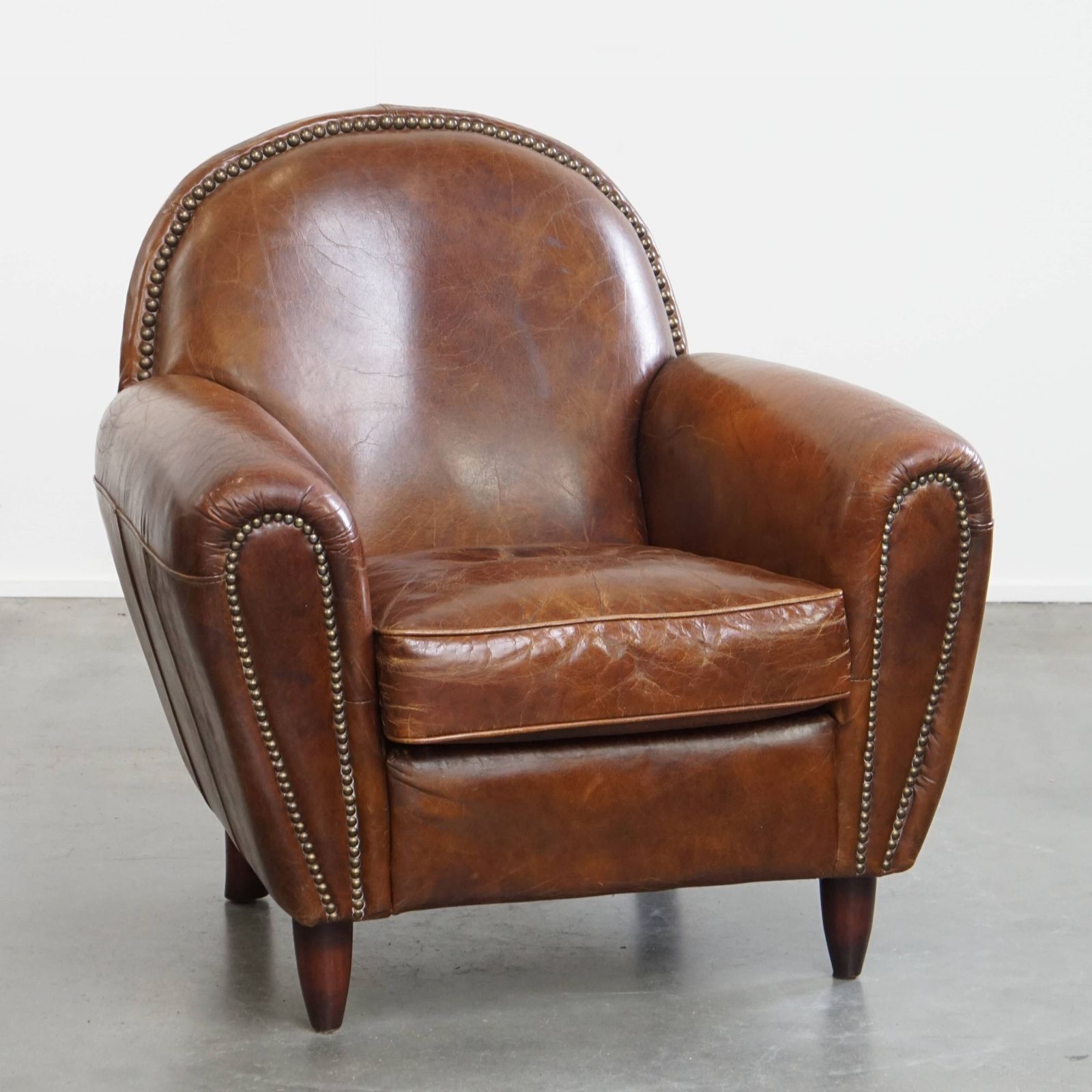 Characterful And Timeless Cowhide Design Armchair With Beautiful Round Shapes And Decorative Nails
