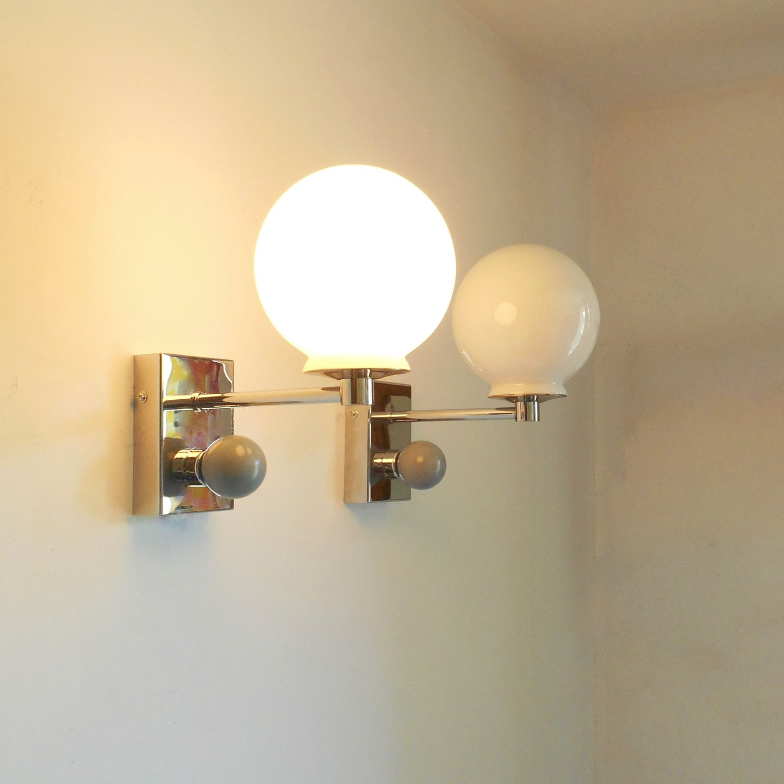 Lighting A Pair Of Unique Silver Chrome Wall Lamps With White Glass Globe Shades photo