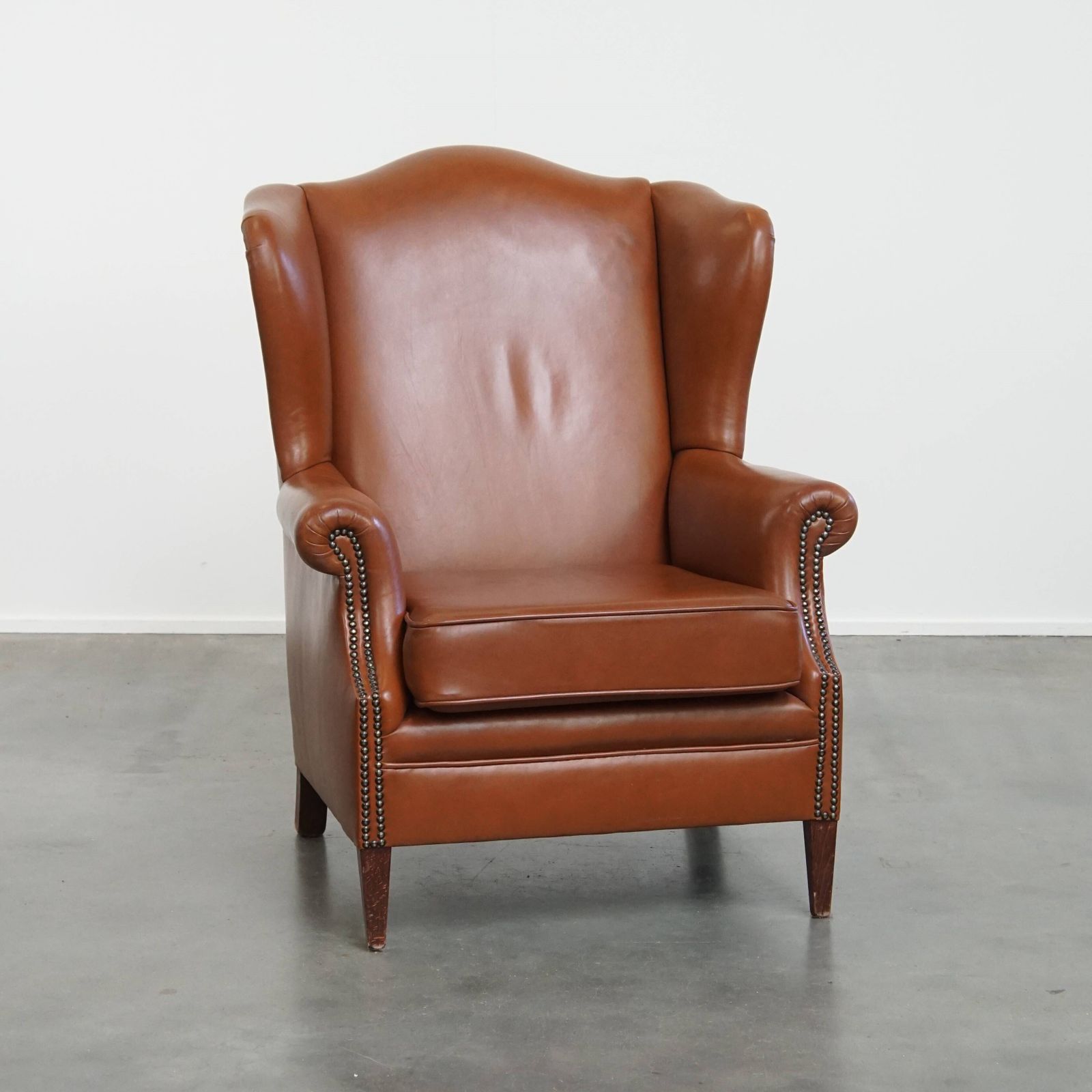 Stylish And In Good Condition Cognac Colored Cowhide Armchair In English Style With Decorative Nails