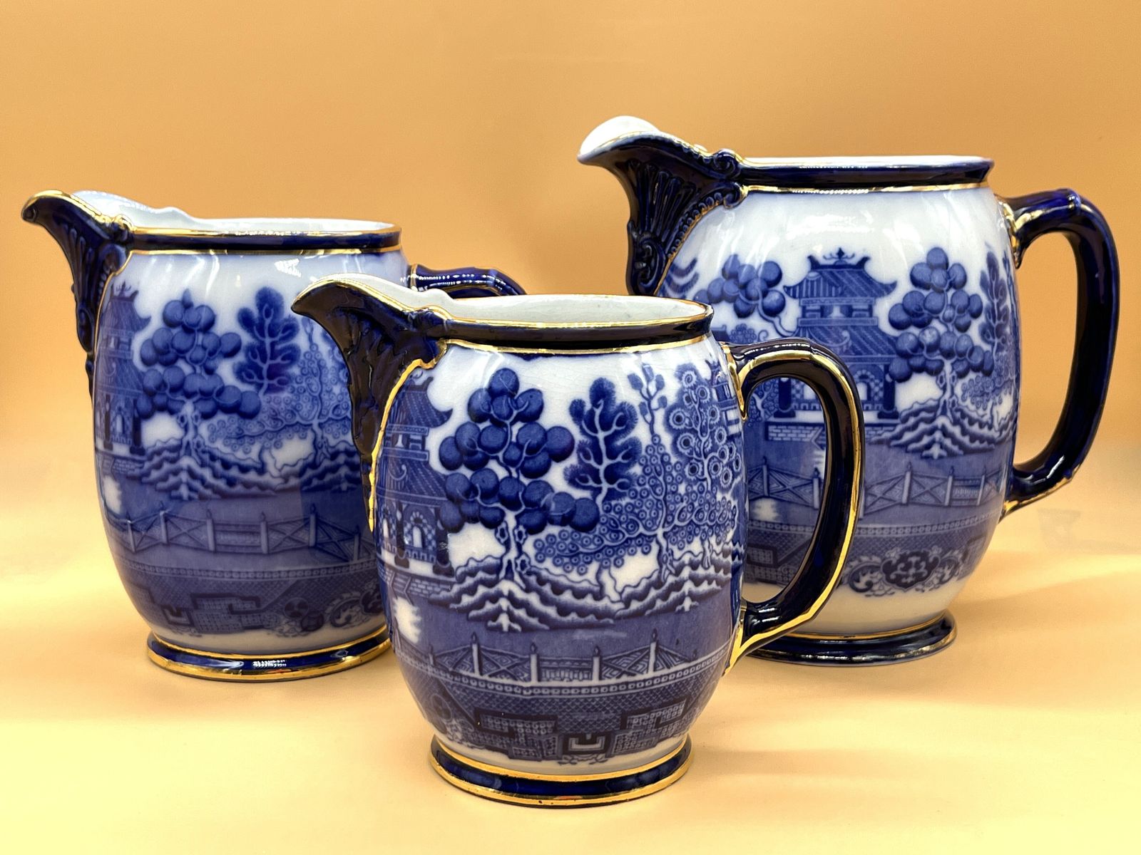 Set Of 3 Antique Royal Doulton Pottery Flow Blue Willow Design Gold Trim Graduated Jugs. 2391. Heights 8", 7" & 6". photo 995.0
