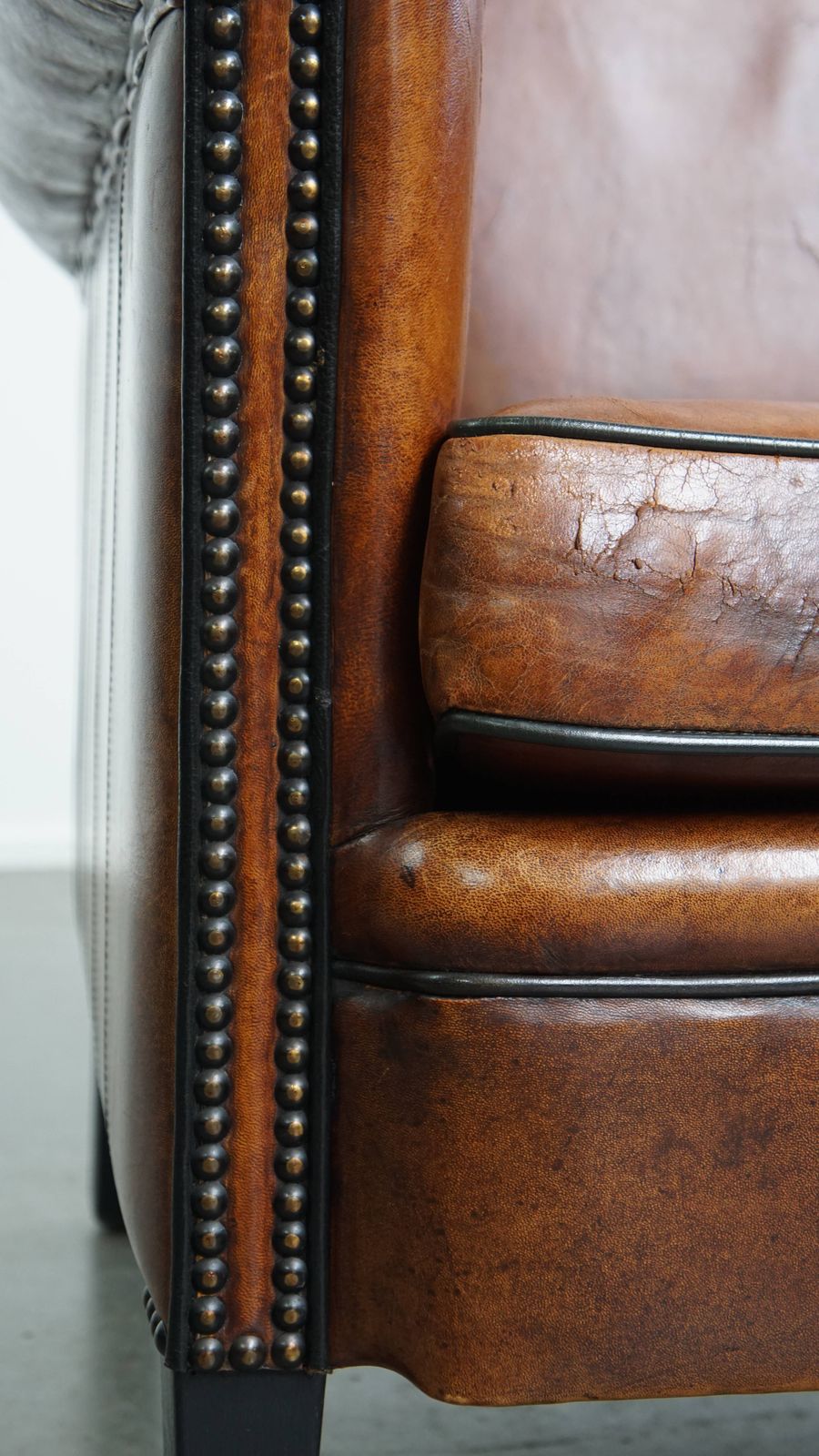 Meubels Stijlvolle Schapenvachten Fauteuil In Warm Cognackleur Met Zwarte Biezenafwerking En Decoratieve Sierspijkers photo