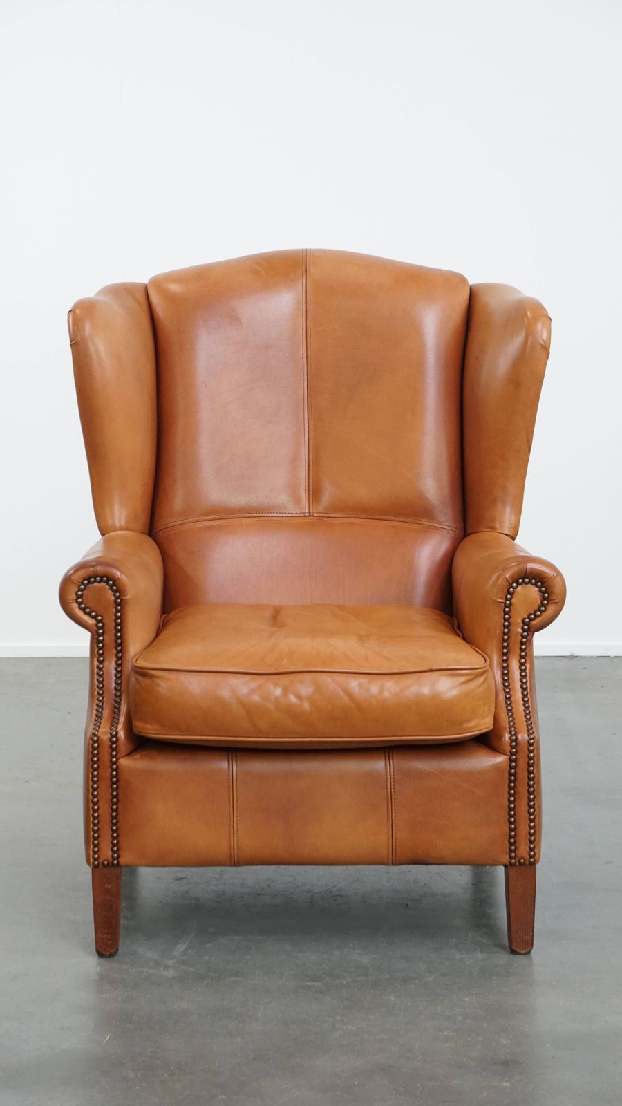 Unique And Comfortable Wing Chair Made Of Cowhide Leather Finished With Decorative Studs And Beautiful Details photo furniture
