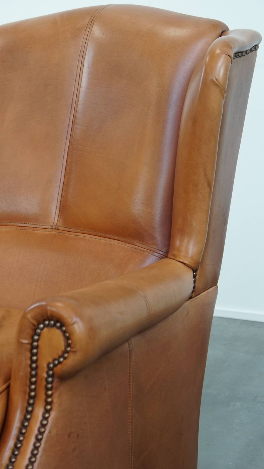 photo furniture Unieke En Comfortabele Wingchair Van Koeienhuidleer Met Decoratieve Sierspijkers En Fraaie Details