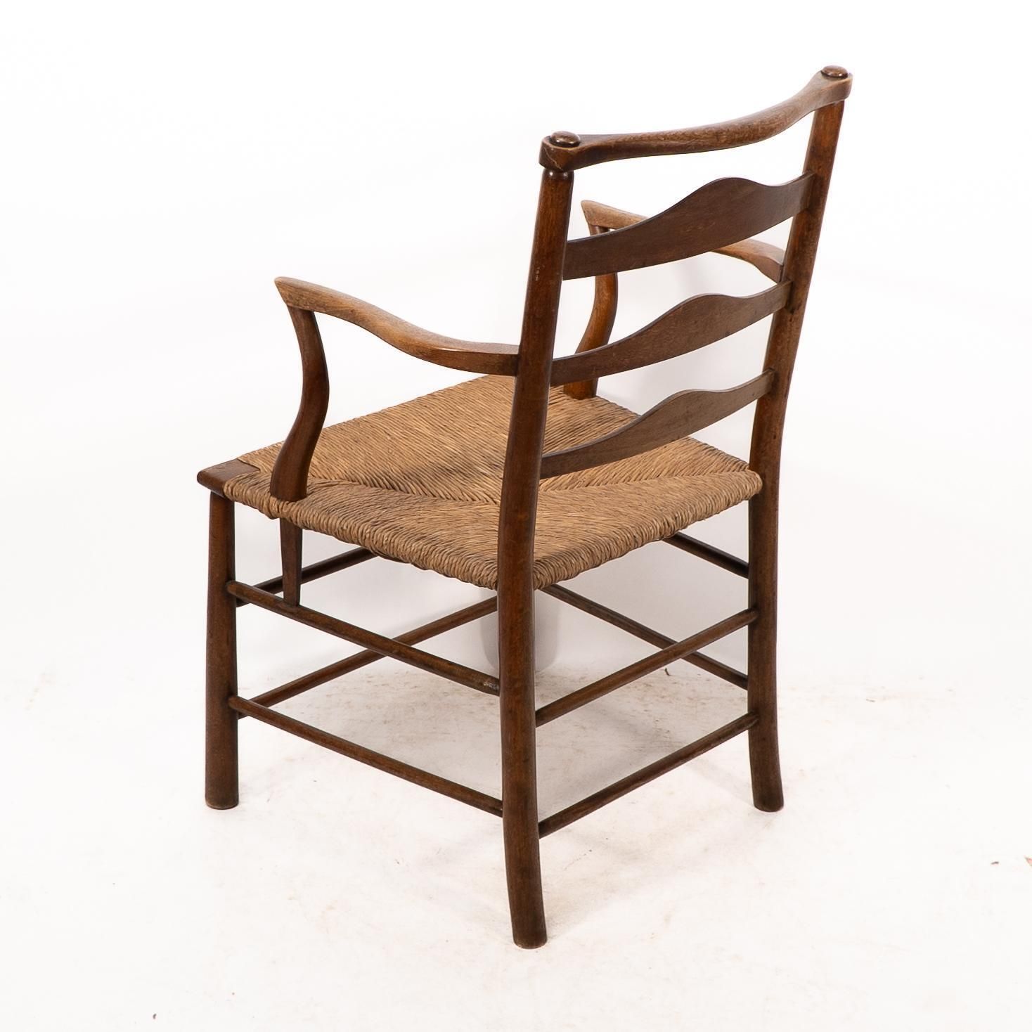 photo buy C R Ashbee. An Arts And Crafts Rush Seat Ladder Back Armchair