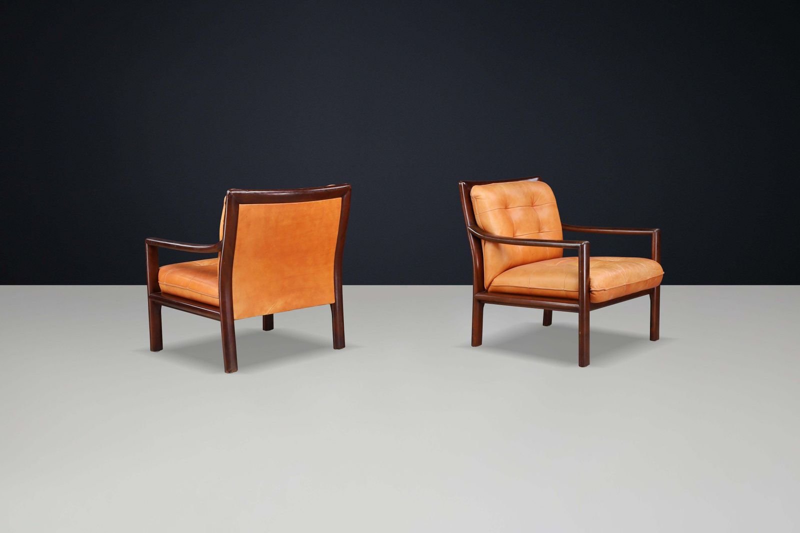 Pair Of Mid Century Lounge Chairs In Cognac Leather & Mahogany Stained Hardwood photo for sale
